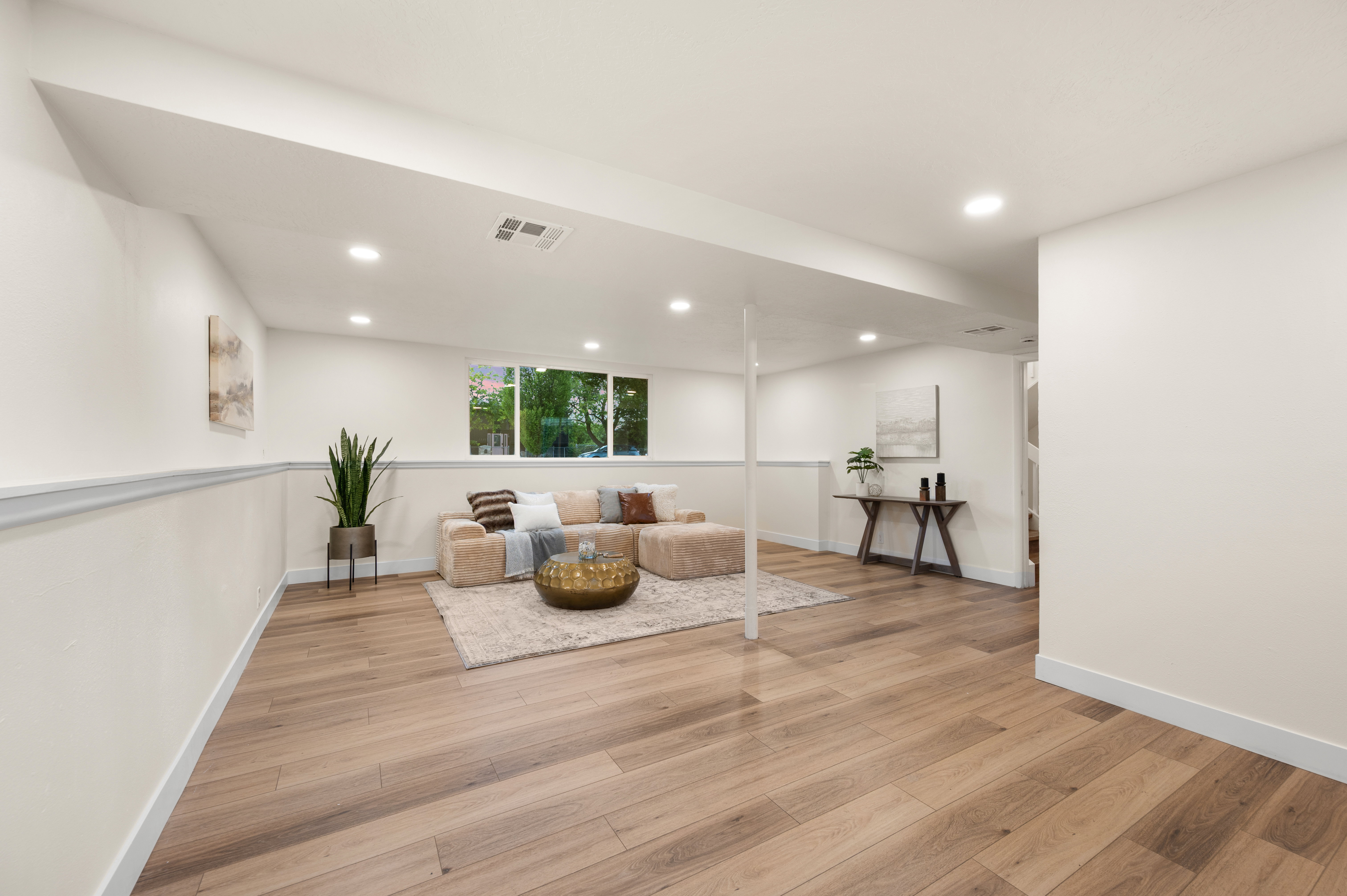 Brightly lit interior space featuring wood-finish flooring, recessed ceiling lights, and white baseboards