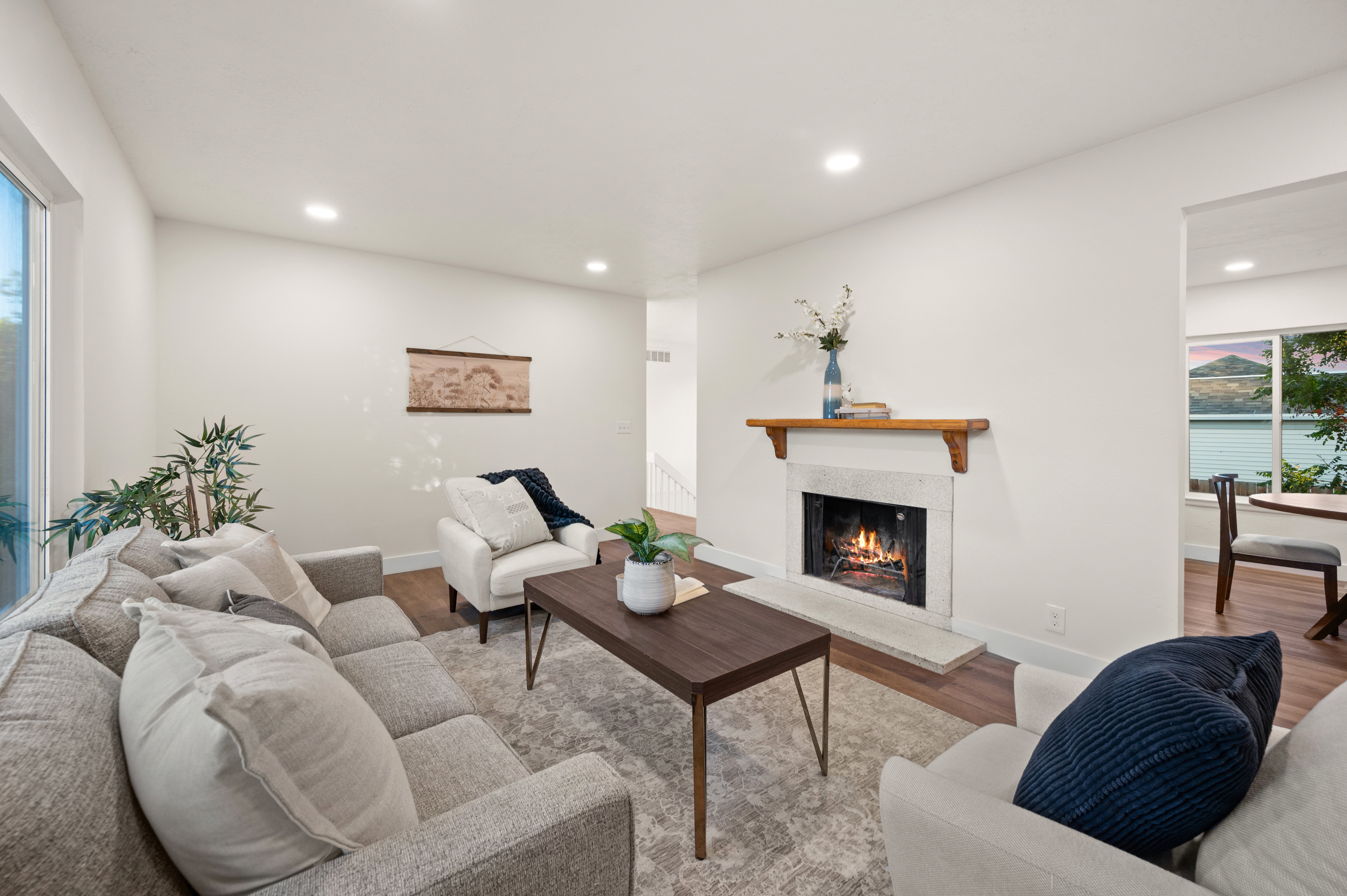 Living area featuring a stone fireplace with a wood mantle, recessed lighting, and wood-finish flooring