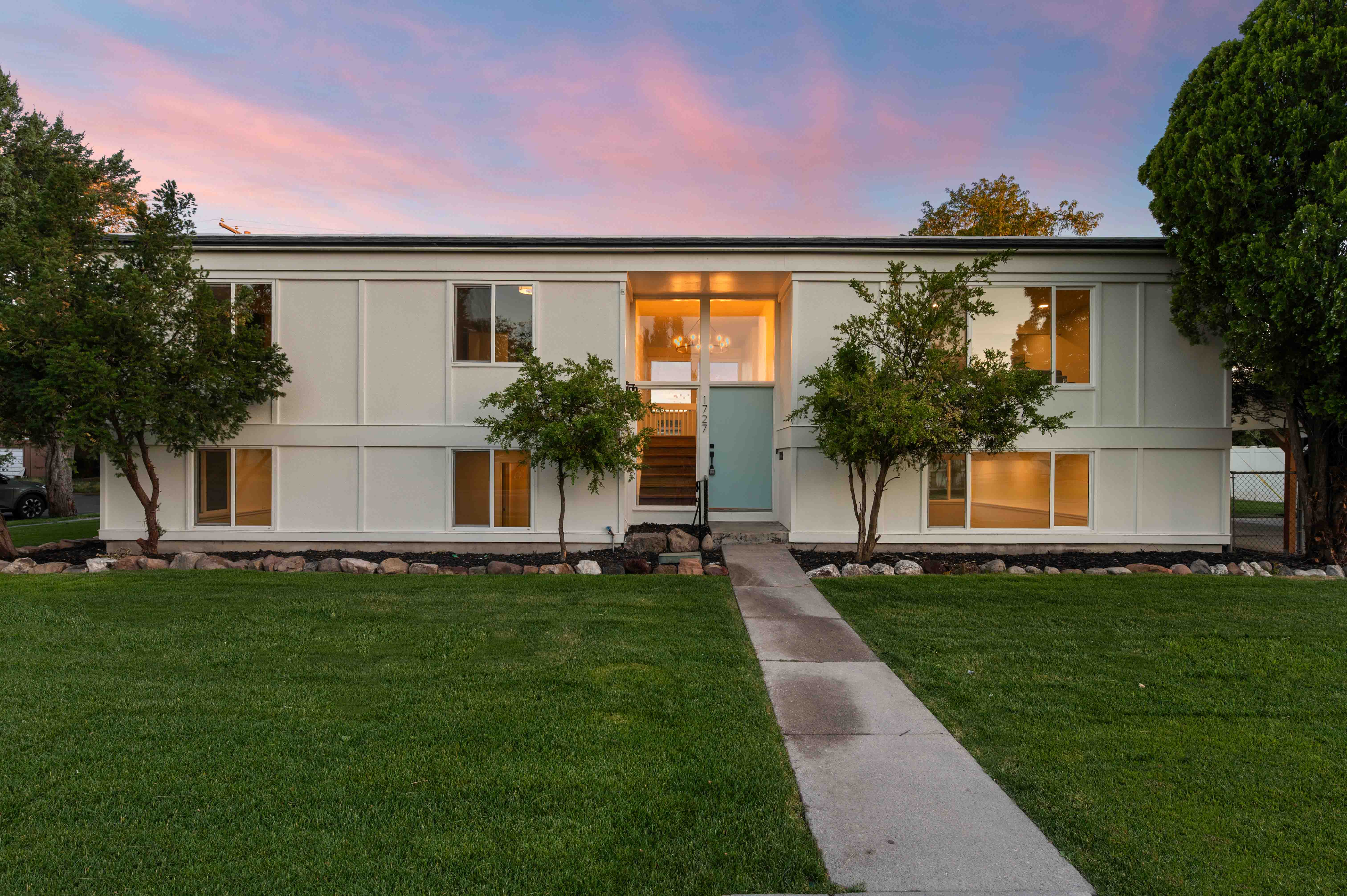 Contemporary two-story exterior with a clean white facade and contrasting dark trim