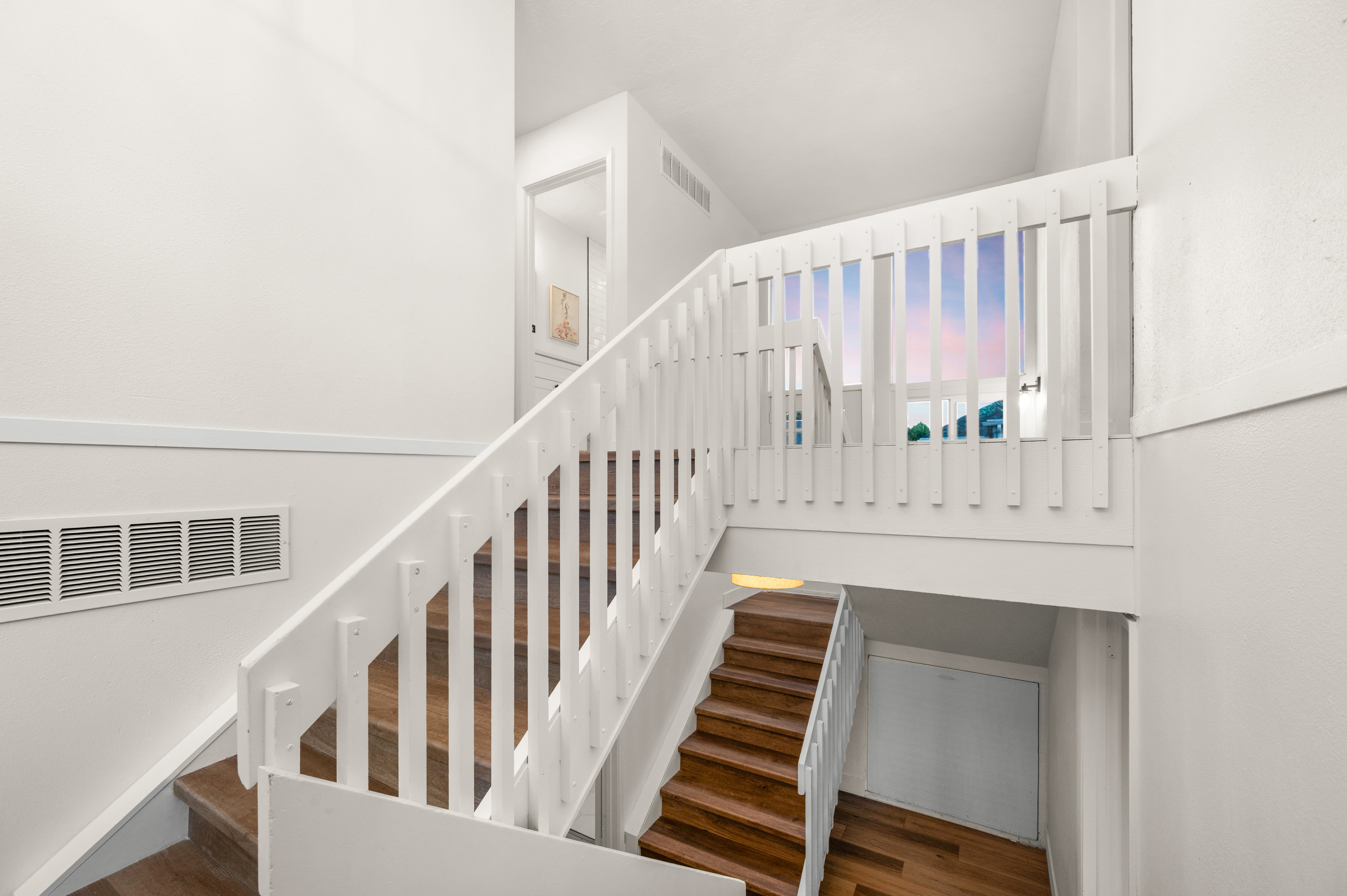 Wood-finish stair treads with white risers and a white painted balustrade