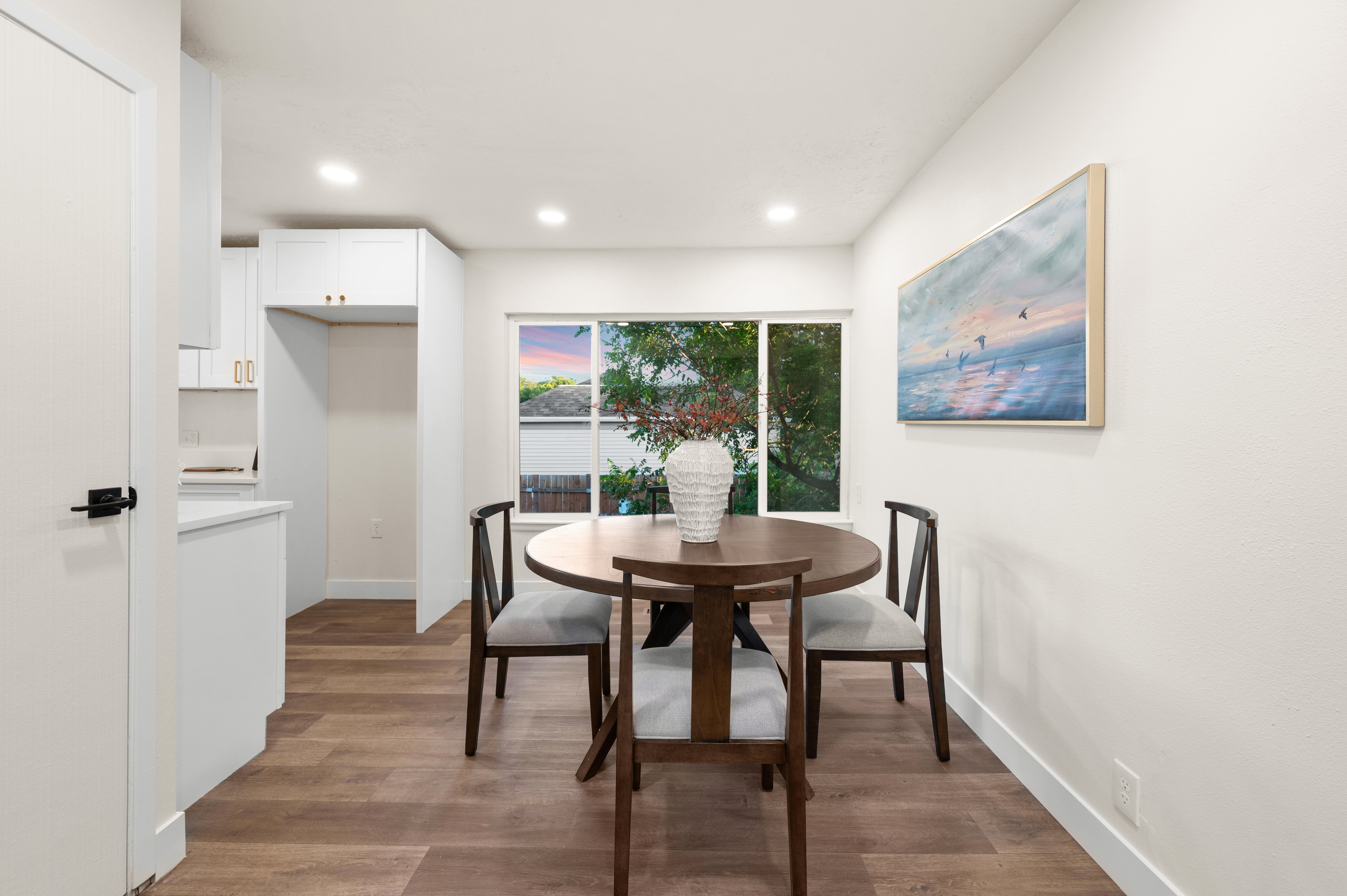 Dining area featuring wood-finish flooring, recessed lighting, a large window, and white trim