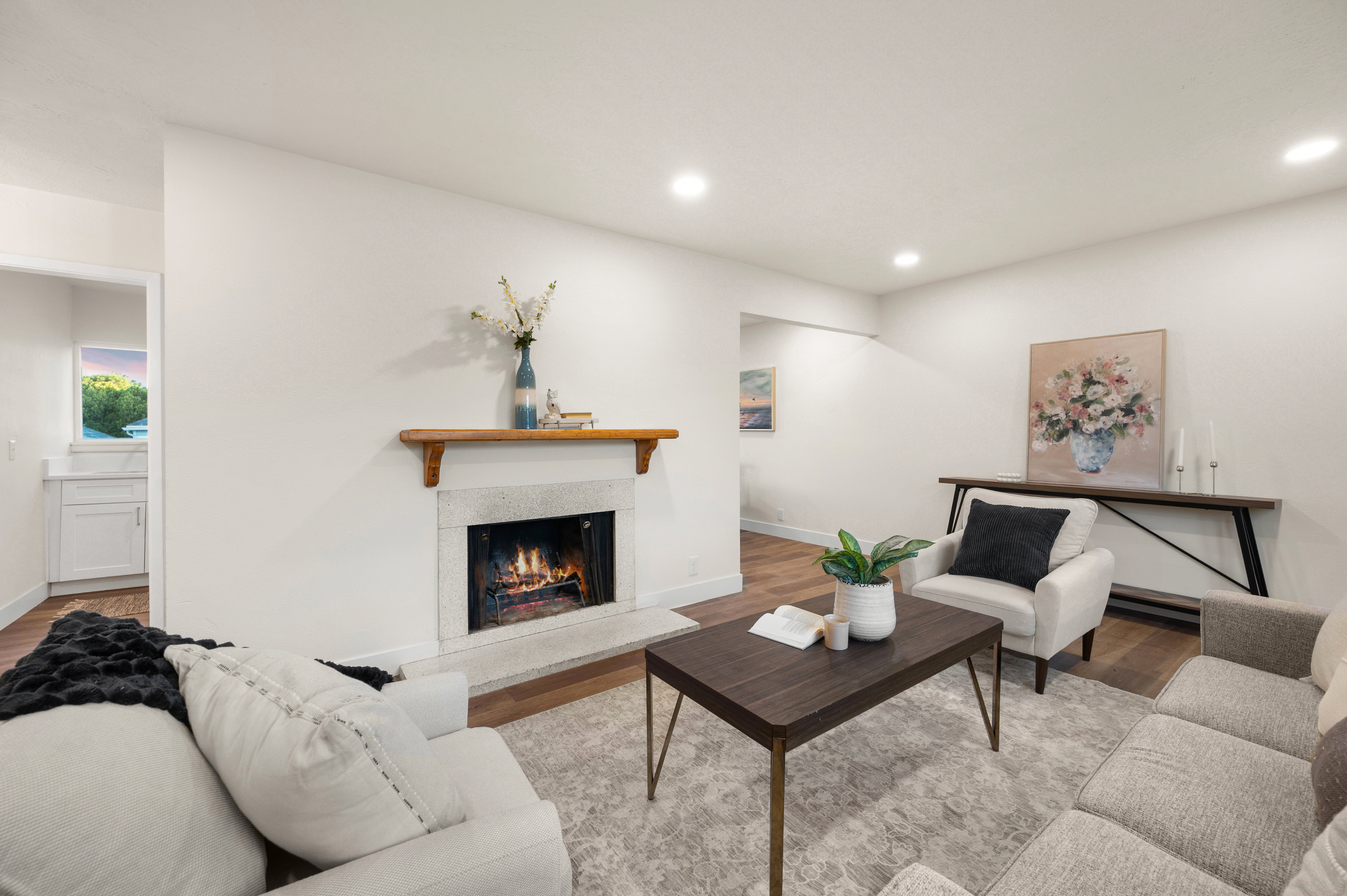 Living area featuring a stone-clad fireplace with a wood mantel, recessed lighting, and wood-finish flooring