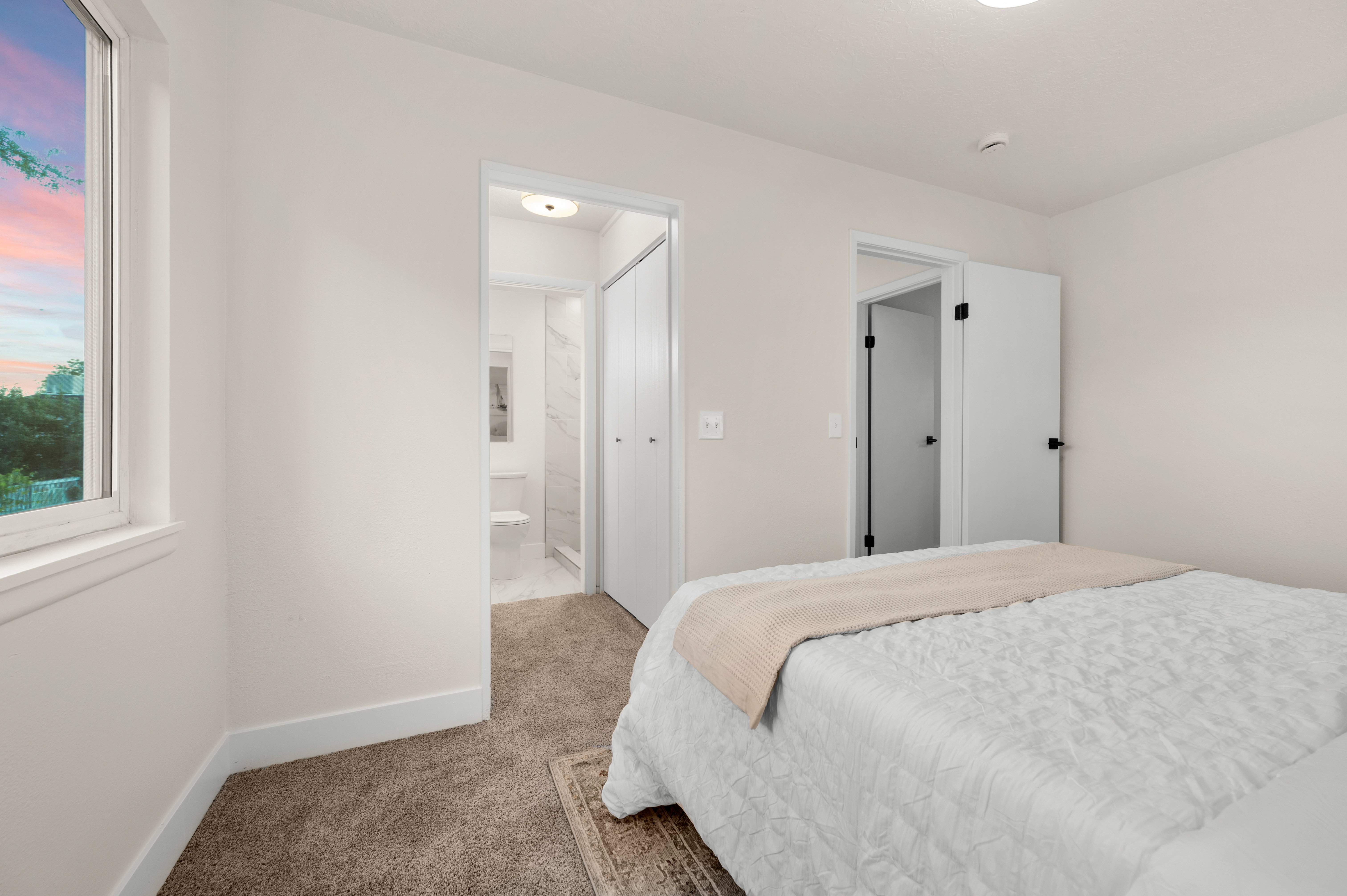 Carpeted room with a double-pane window and white trim