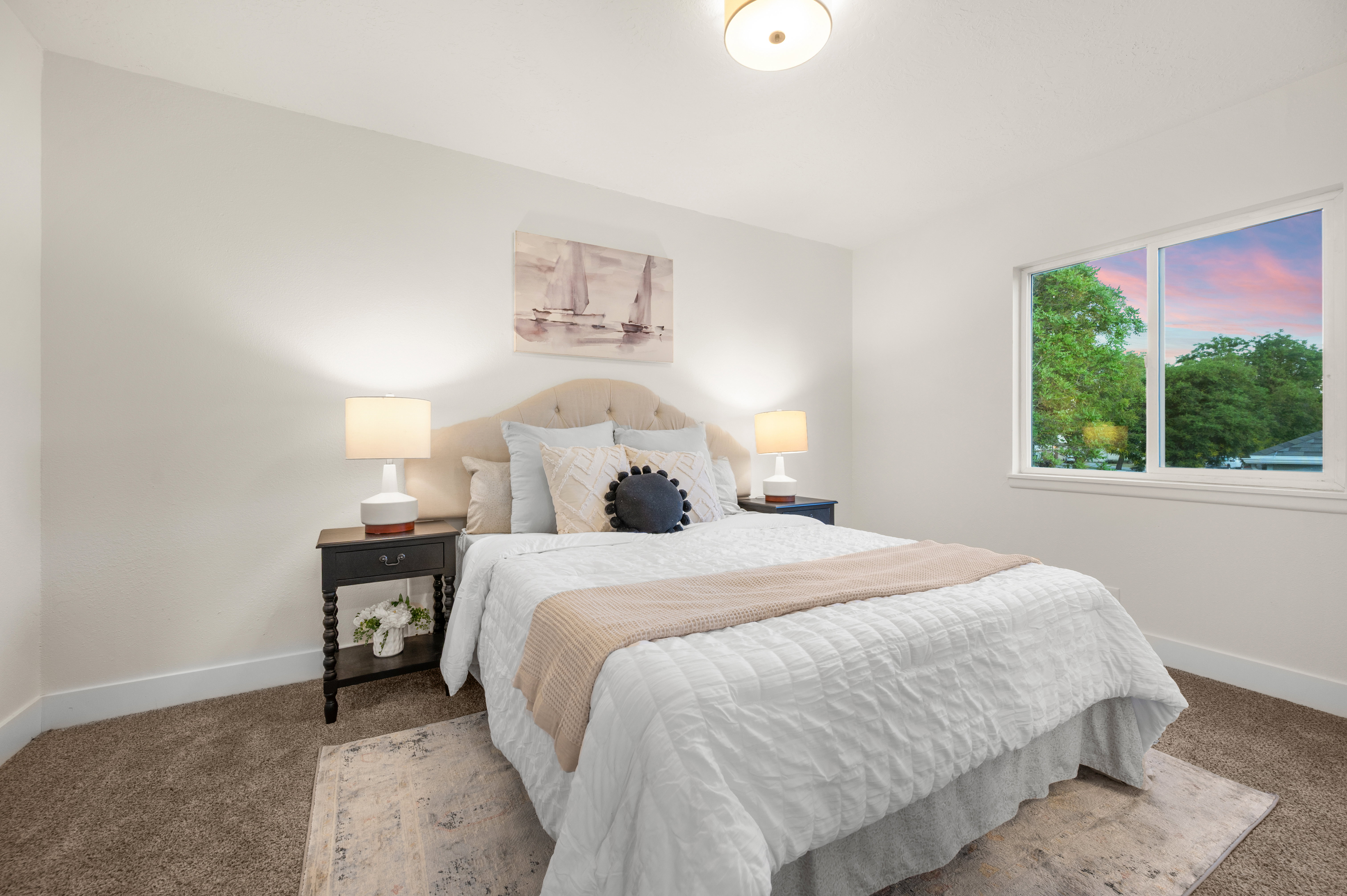 Bedroom featuring a tufted upholstered headboard, a large window, recessed lighting, and neutral carpeting