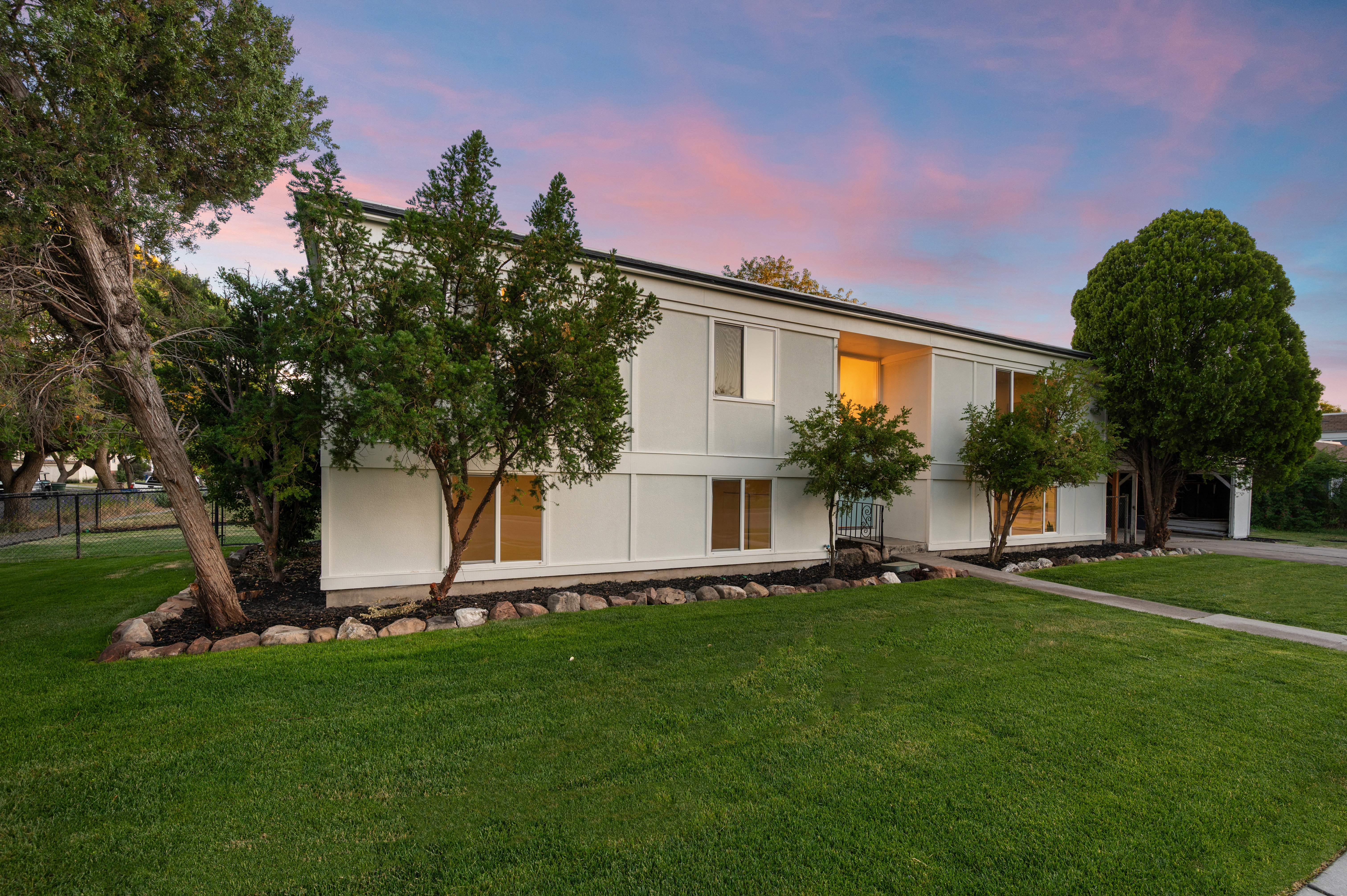 Two-story exterior with light-toned siding, a deep setback, and a concrete walkway