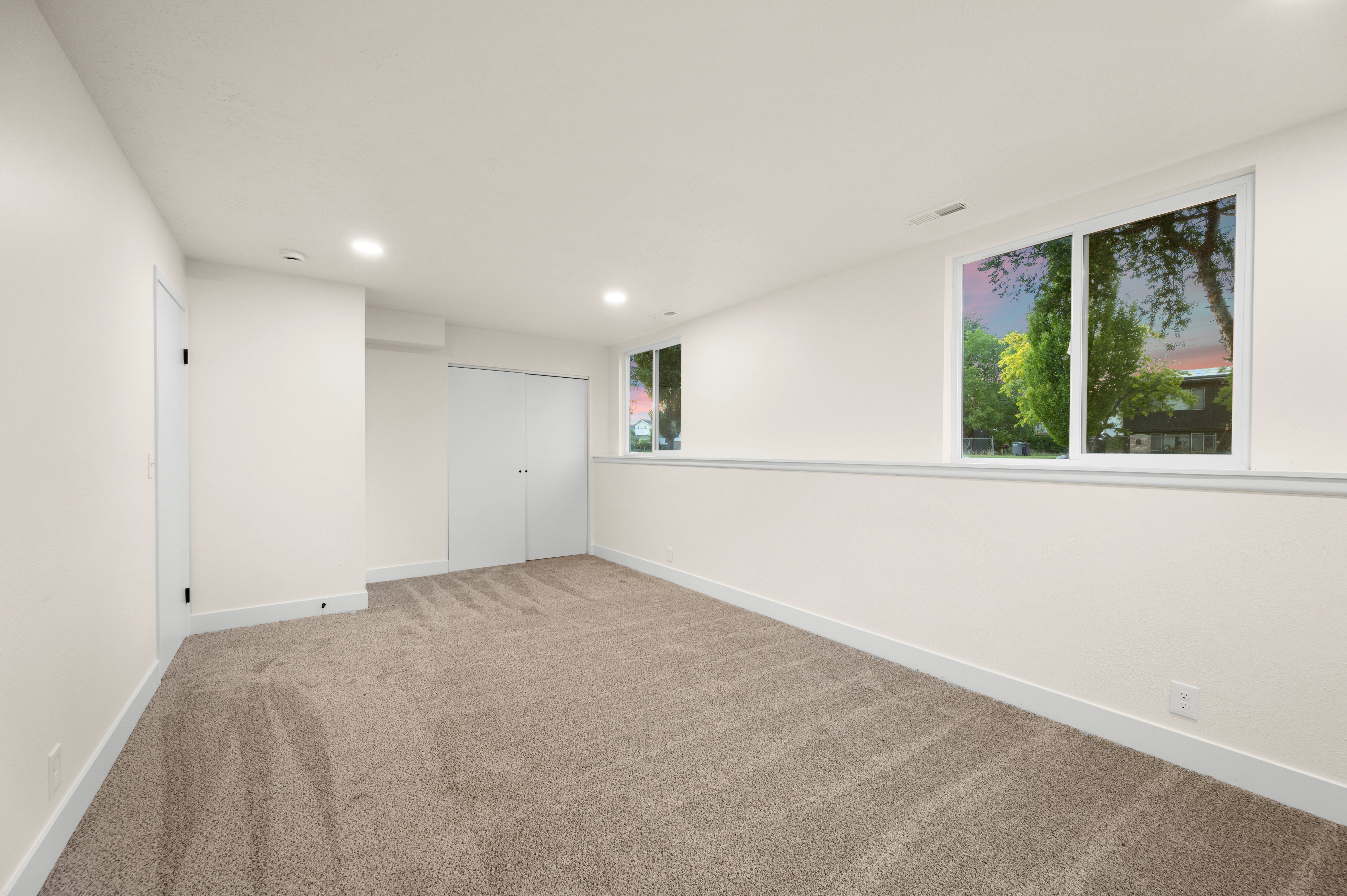 Spacious room with plush carpet flooring, recessed lighting, and white trim