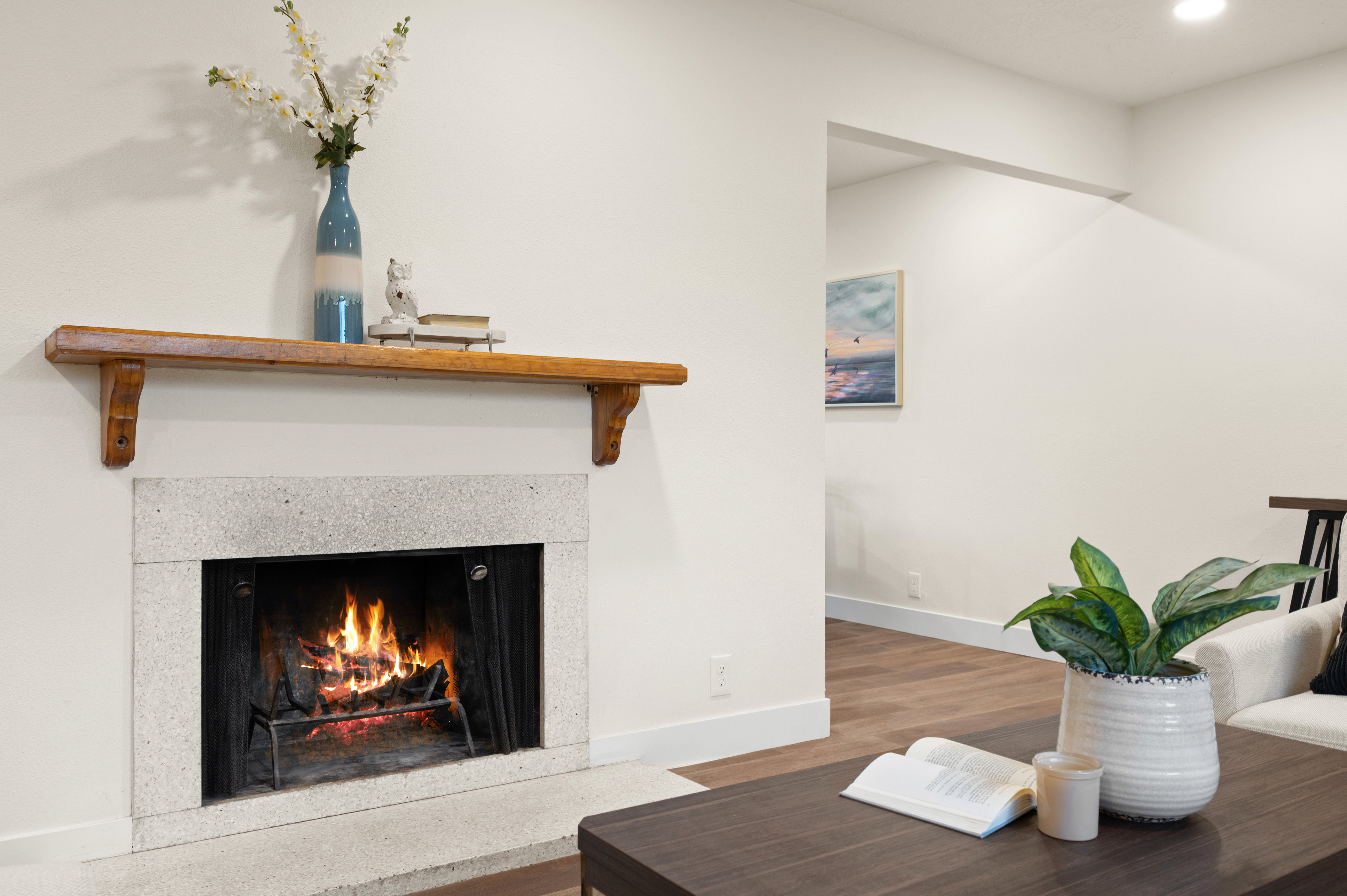 Fireplace featuring a light-toned stone surround, a wooden mantel, and a hearth