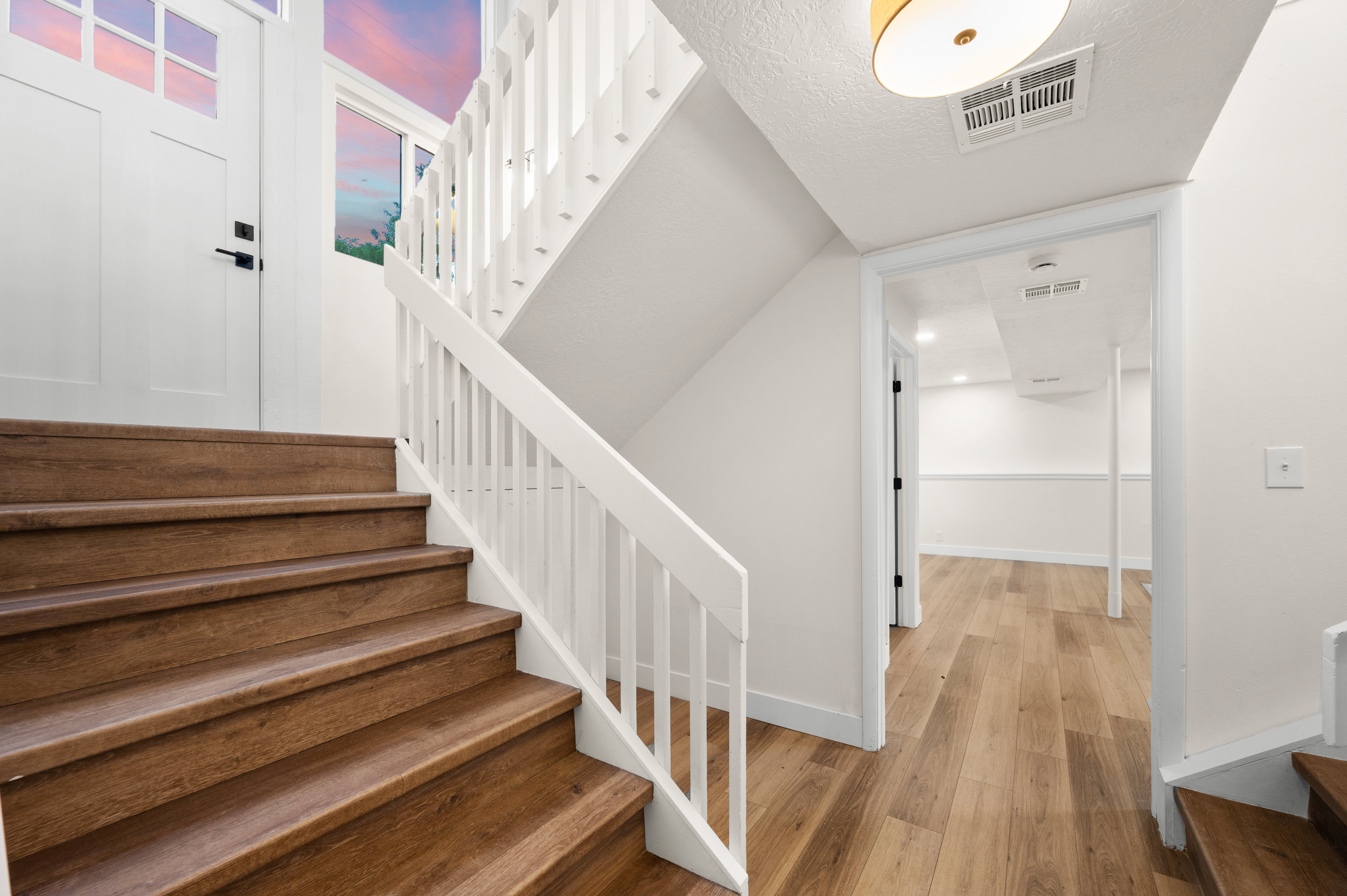 Staircase featuring wood-finish treads and white spindle railings