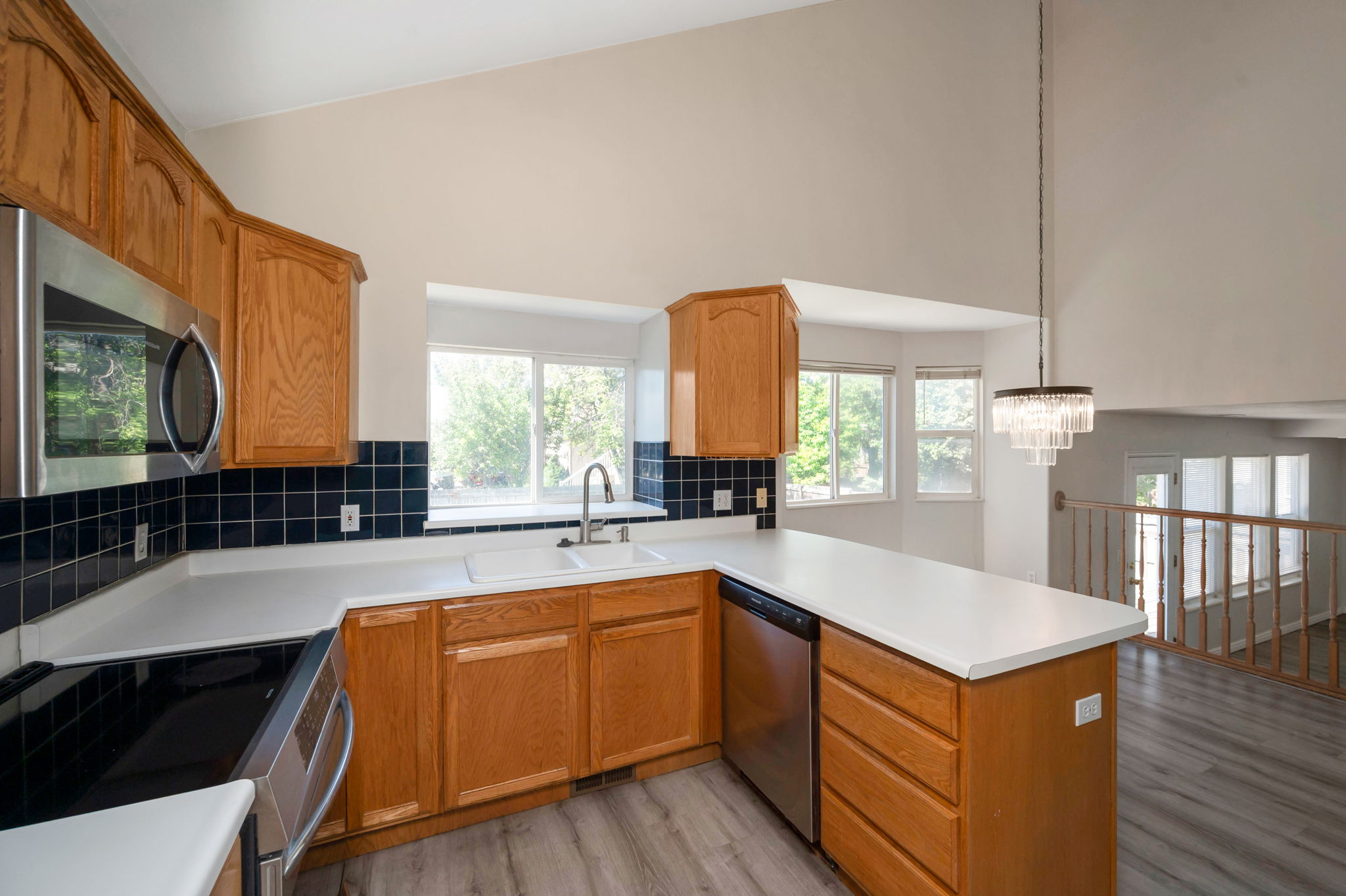 Kitchen featuring wood cabinetry, a double basin sink, stainless steel appliances, and wood-finish flooring