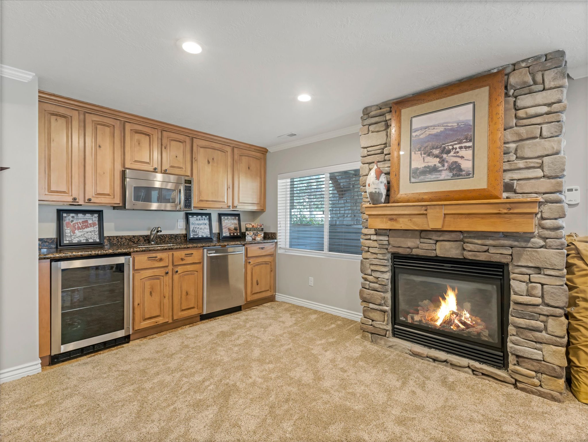 Basement room featuring a kitchenette with wine fridge and a gas fireplace.
