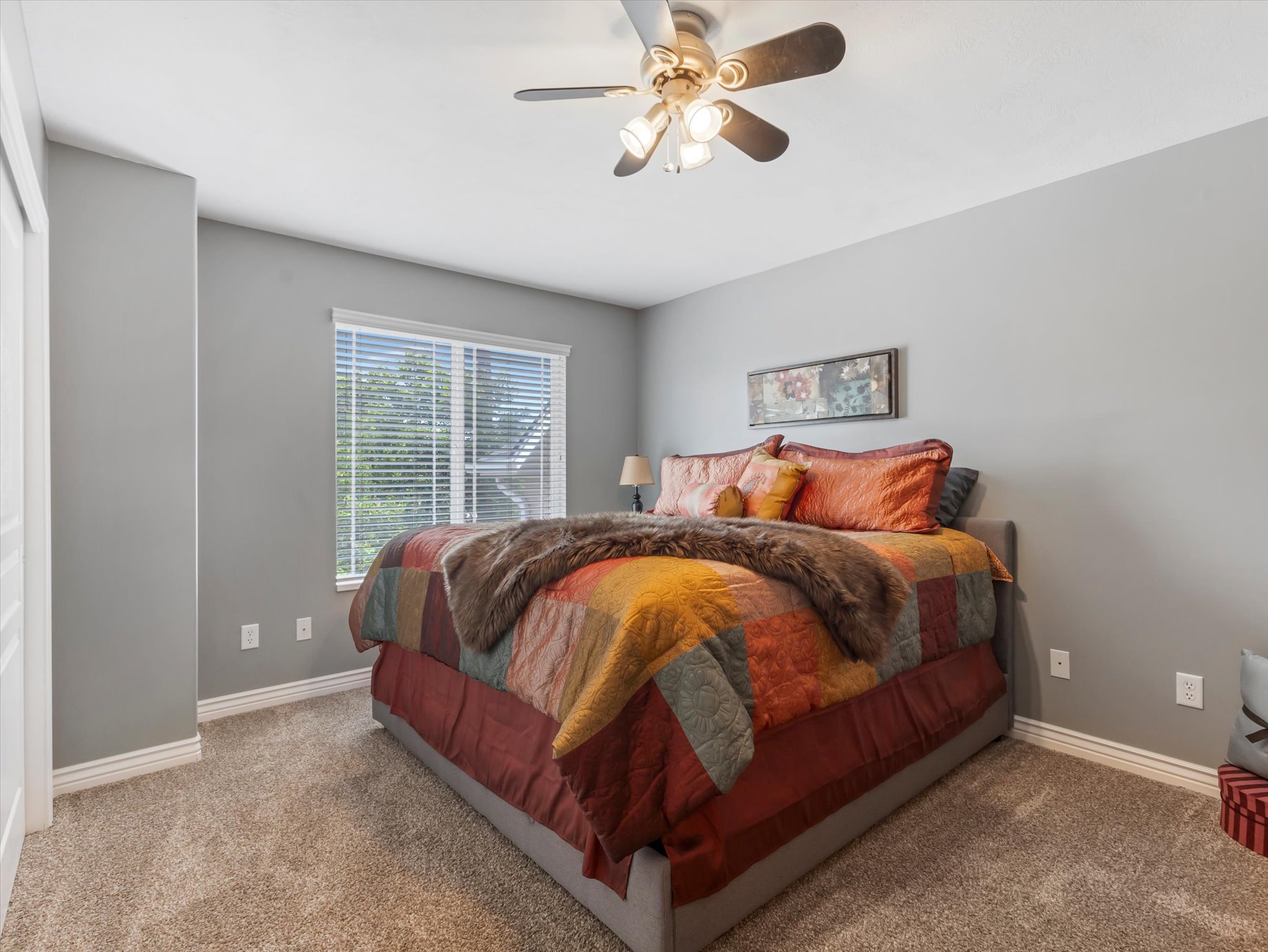 Secondary bedroom featuring a window with blinds, a ceiling fan with integrated lighting, and white baseboards