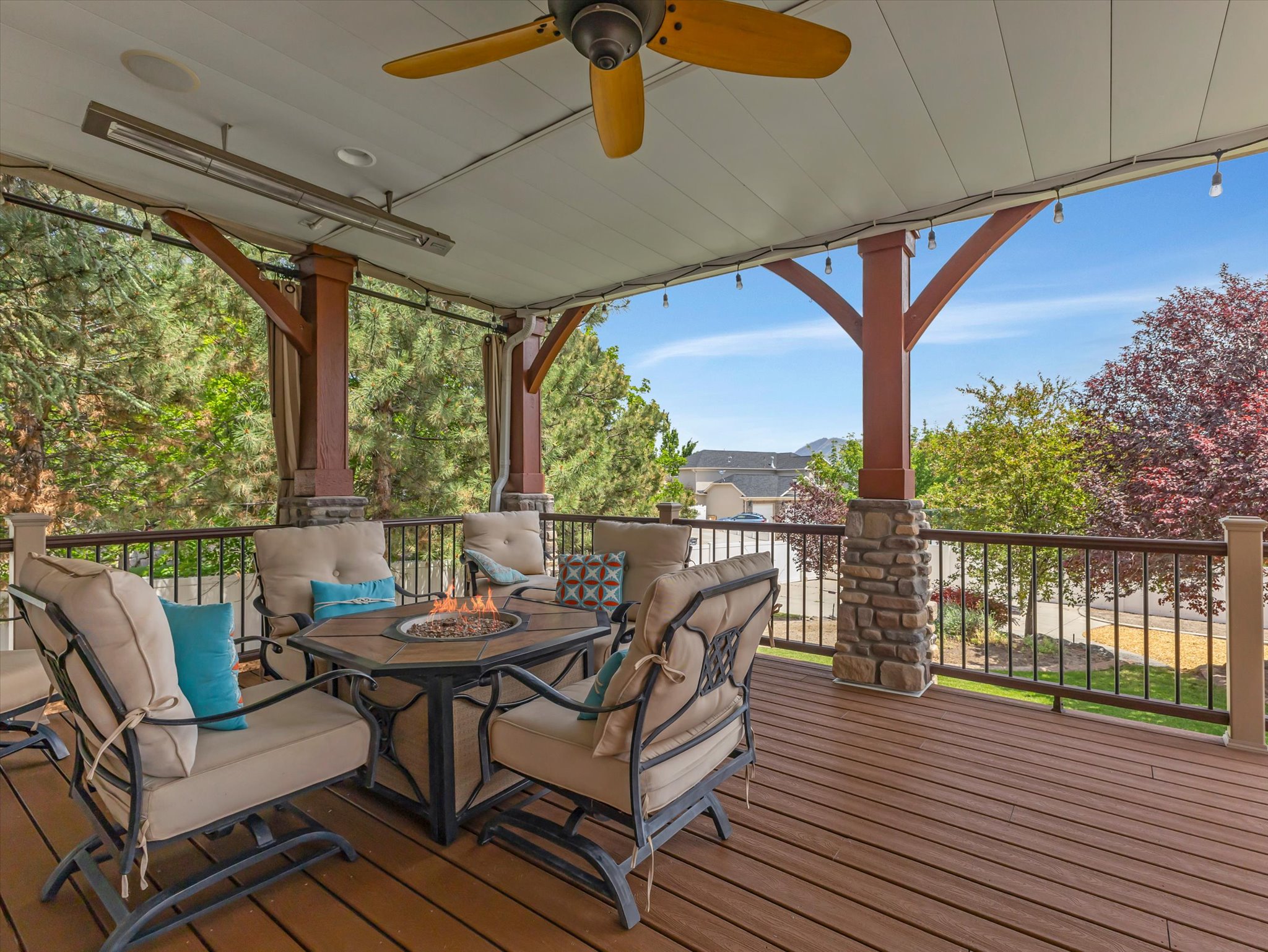 Just off the kitchen, the main floor back deck with mountain views and an outdoor firepit and television.