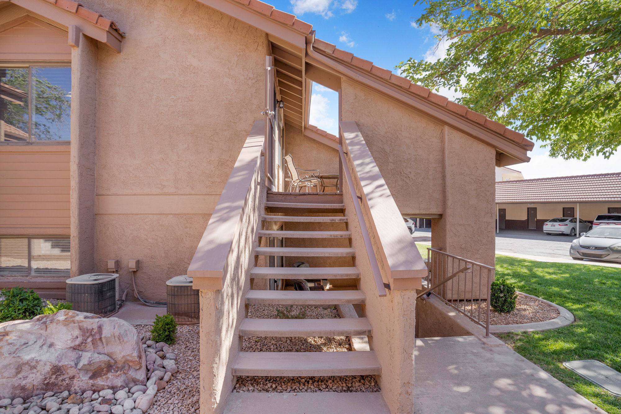 Exterior stairway access featuring stucco siding and tile roofing