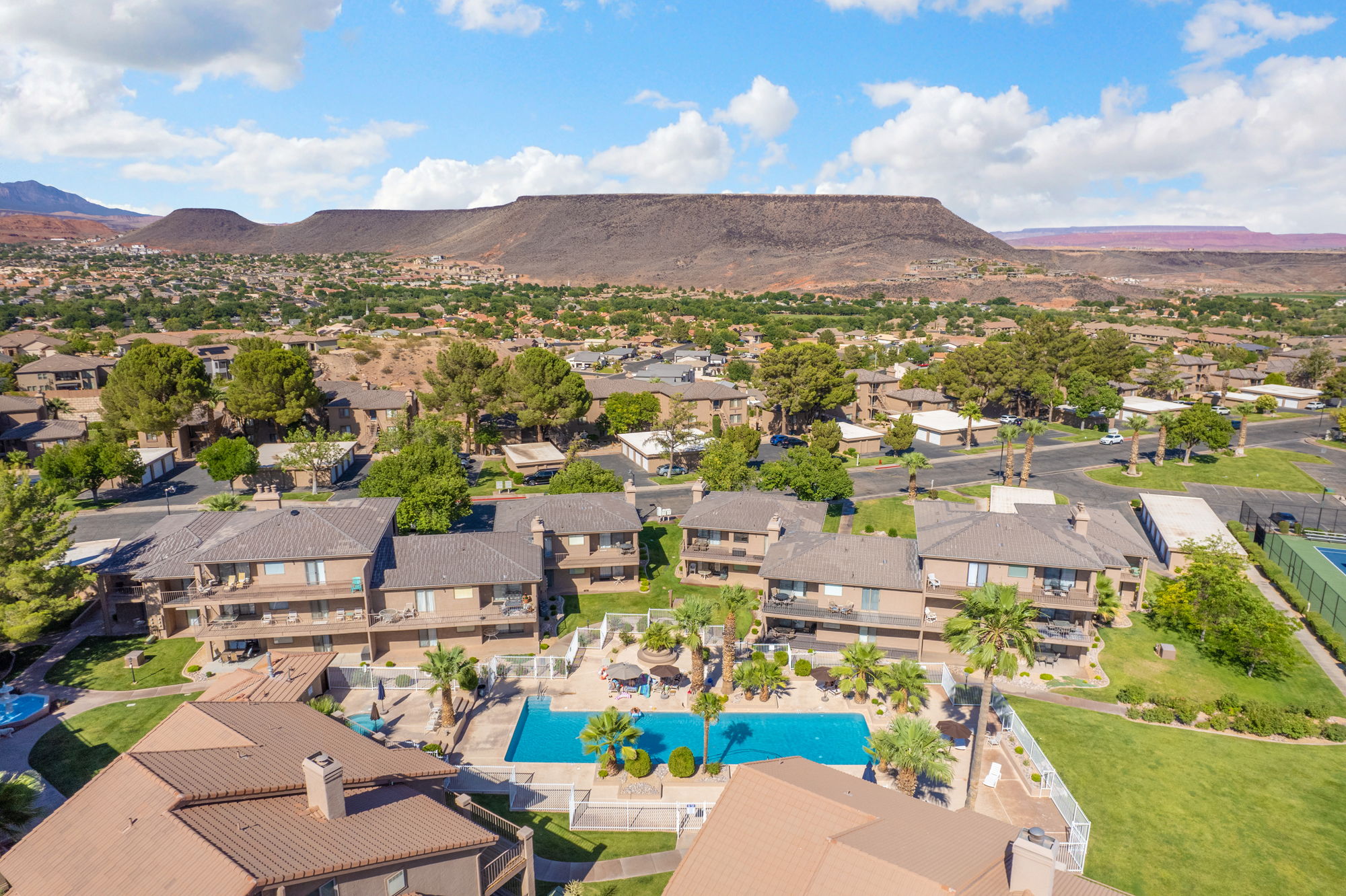 Aerial view of a residential complex featuring multiple buildings with terracotta-style roofs