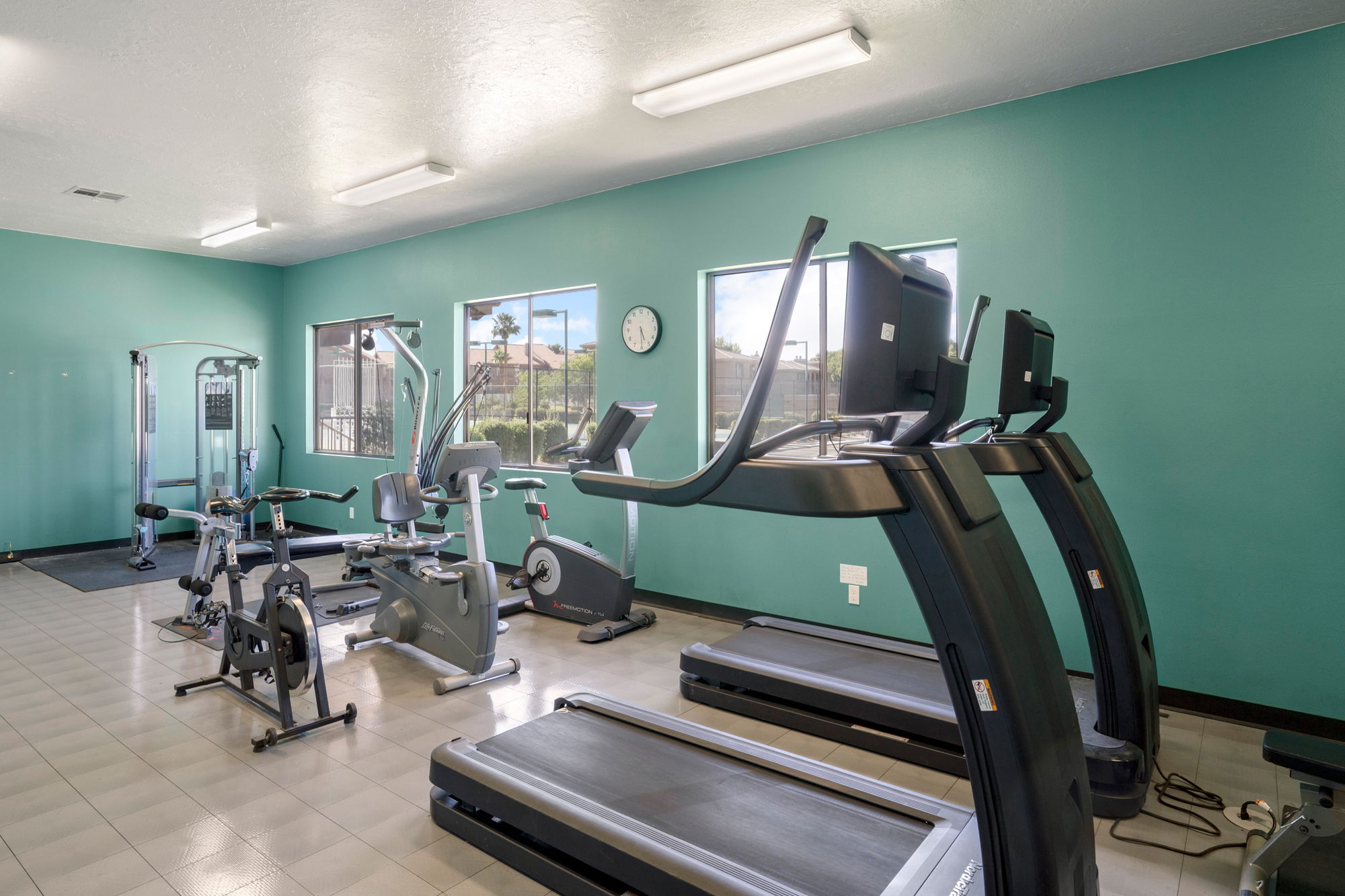 Fitness room with light teal walls and recessed fluorescent lighting