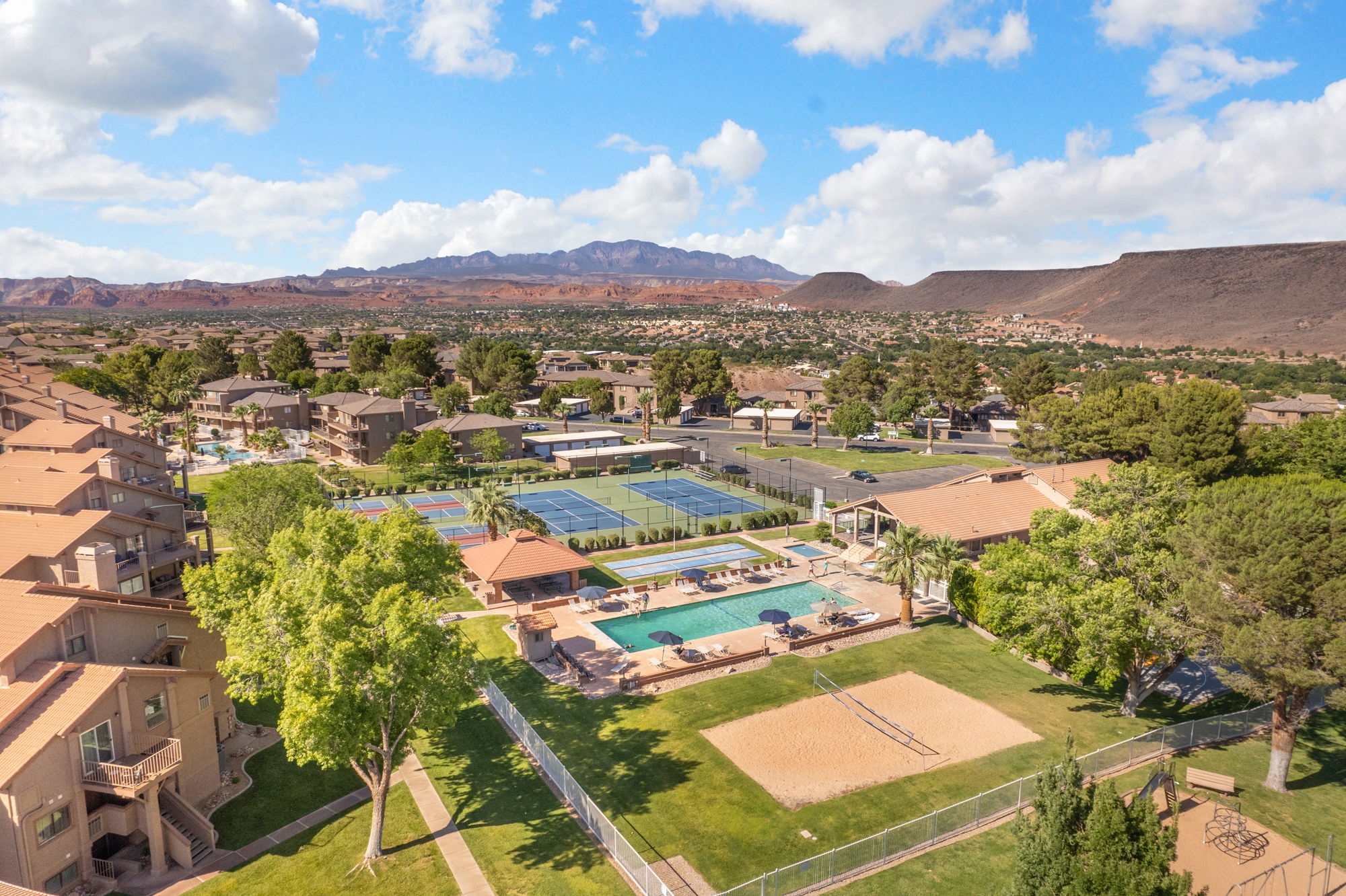 Community amenities featuring two swimming pools, two tennis courts, a sand volleyball court, and a clubhouse