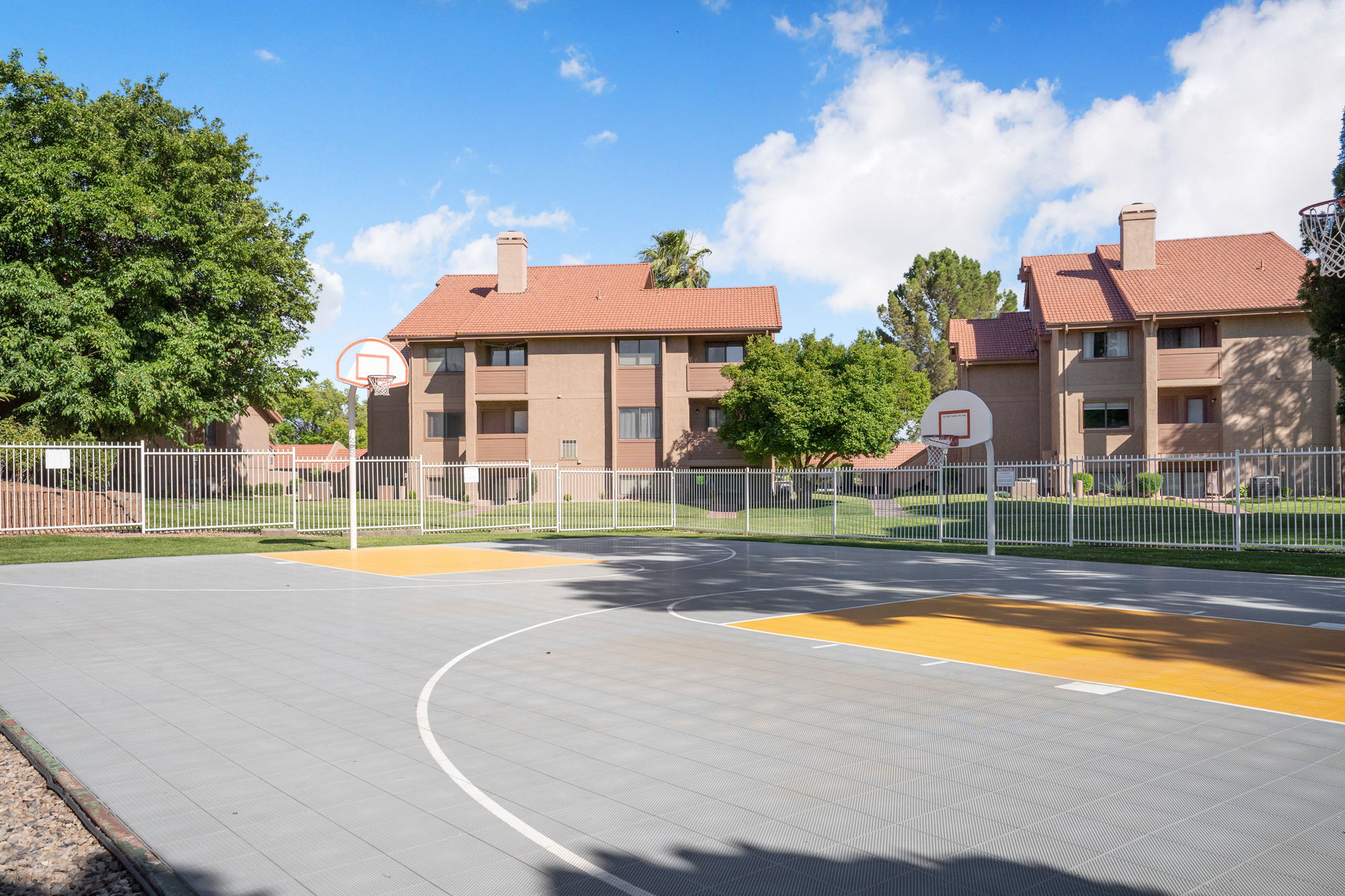 Outdoor basketball court with grey and yellow playing surfaces