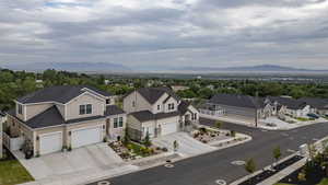 Newly constructed residence featuring a two-story design with a double garage, stone accents, and manicured landscaping