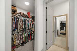 Walk-in closet with carpet flooring, recessed lighting, and dual-level hanging rods