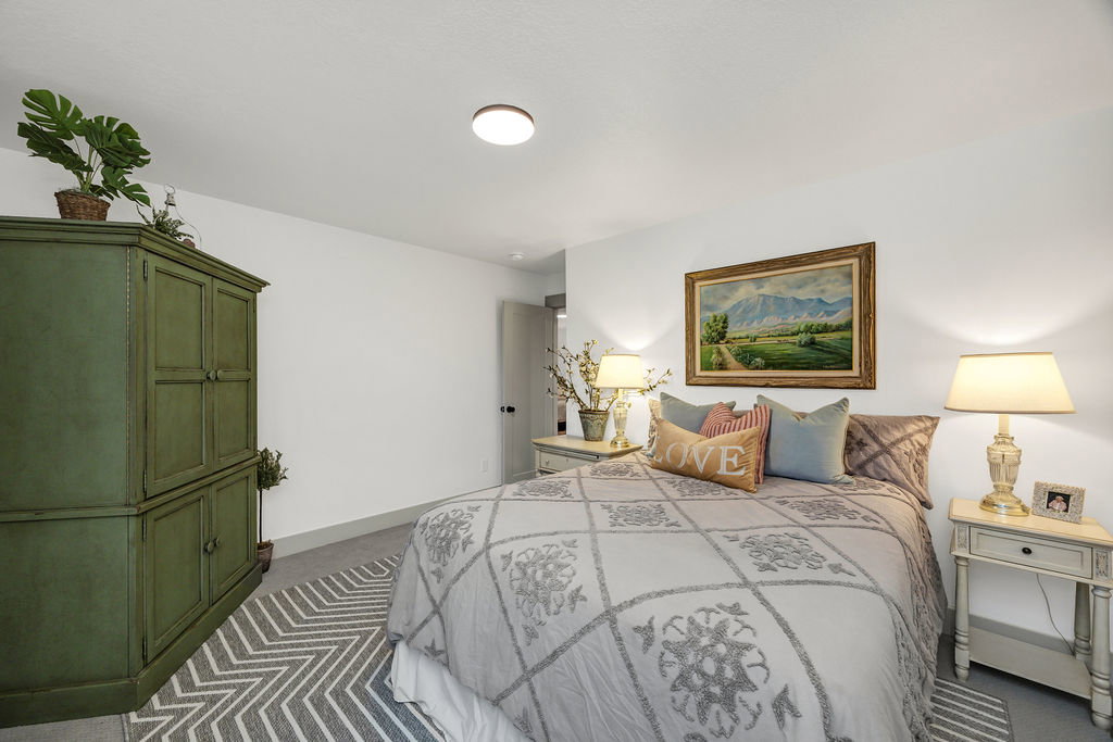 Carpeted bedroom featuring white walls and a ceiling light fixture