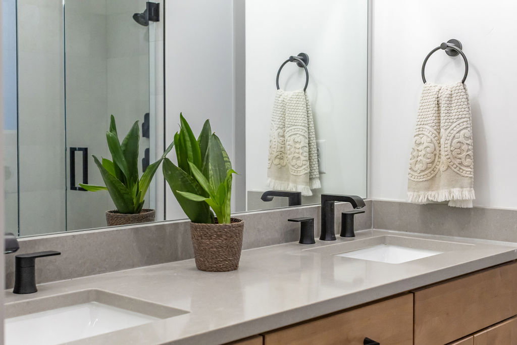 Dual undermount sinks set within a light-toned countertop, complemented by matte black faucets
