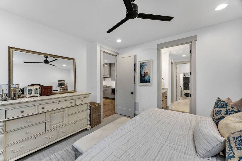 Recessed lighting and a matte black ceiling fan illuminate this interior space