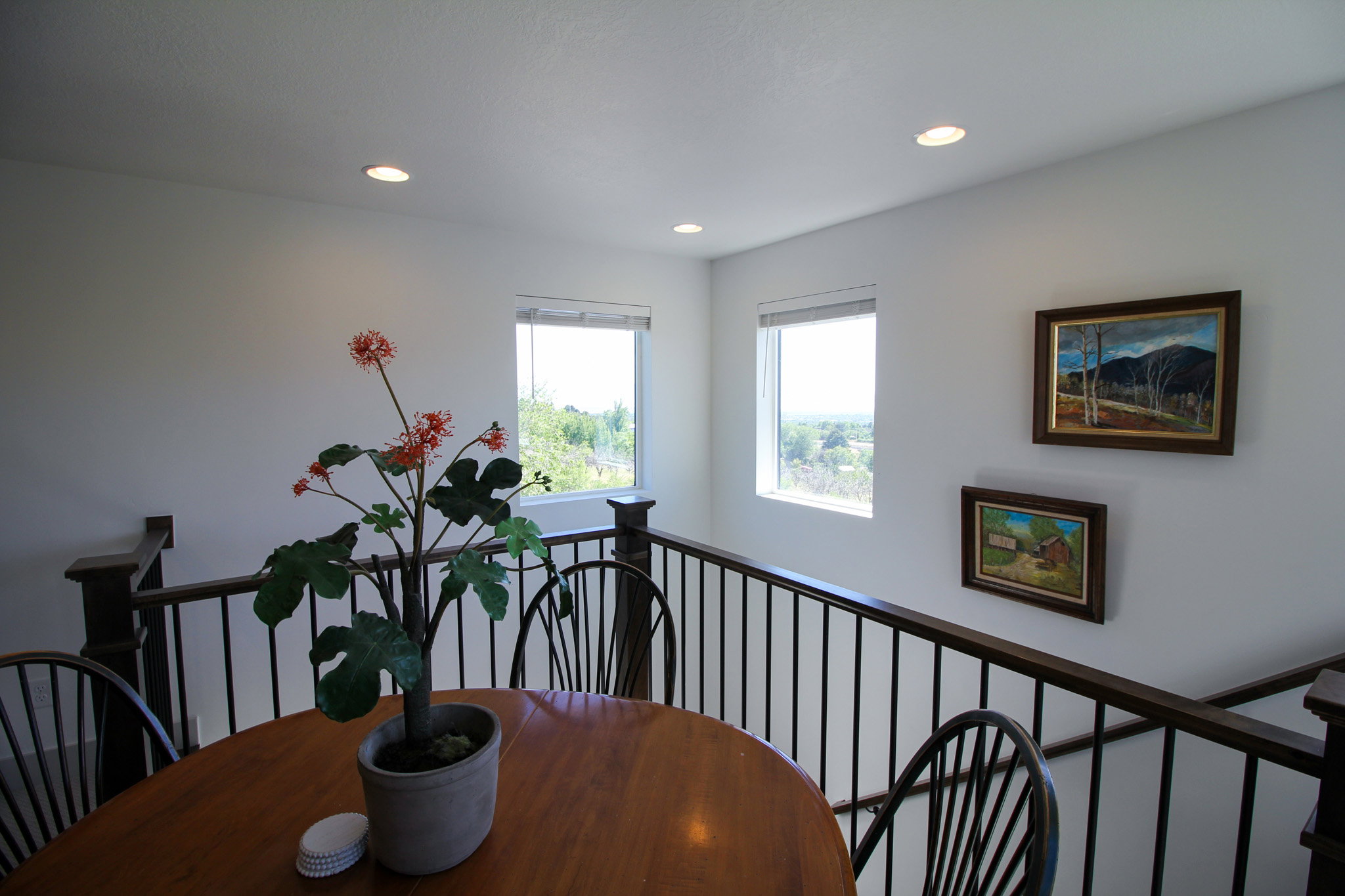 Upper-level landing featuring a dark wood railing with black metal spindles
