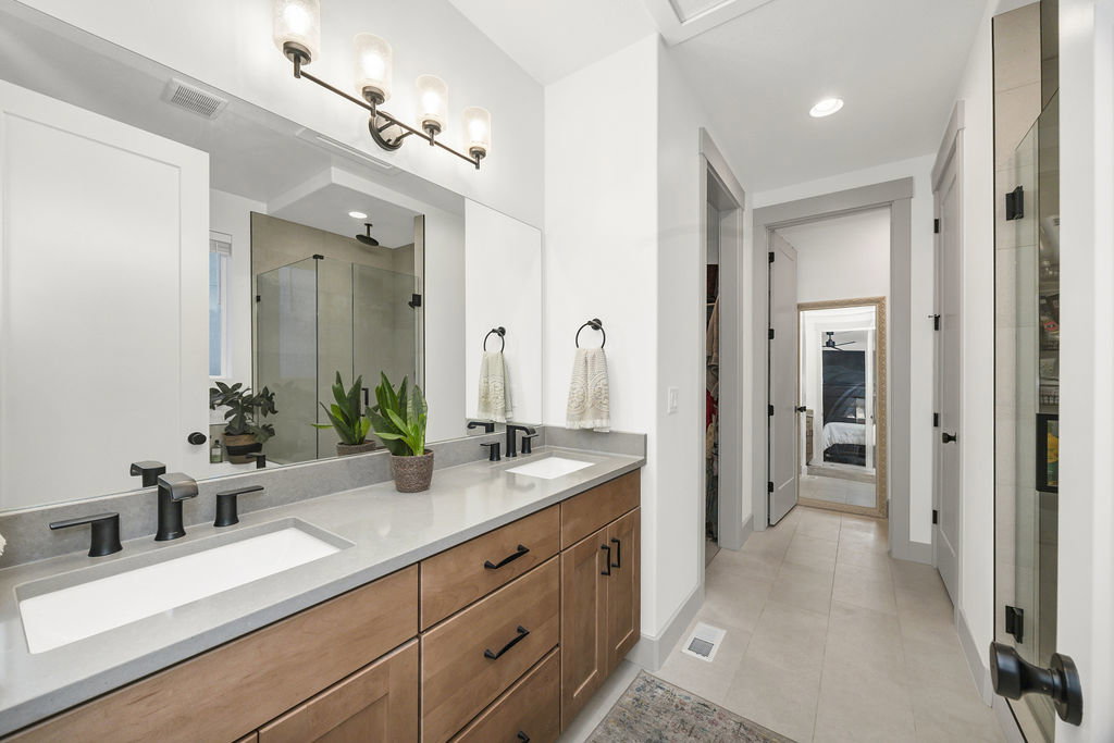 Dual vanity with integrated sinks, stone-finish countertop, and wood-finish cabinetry