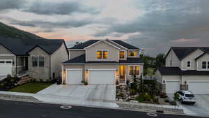 Contemporary two-story residence featuring light siding and stone veneer accents