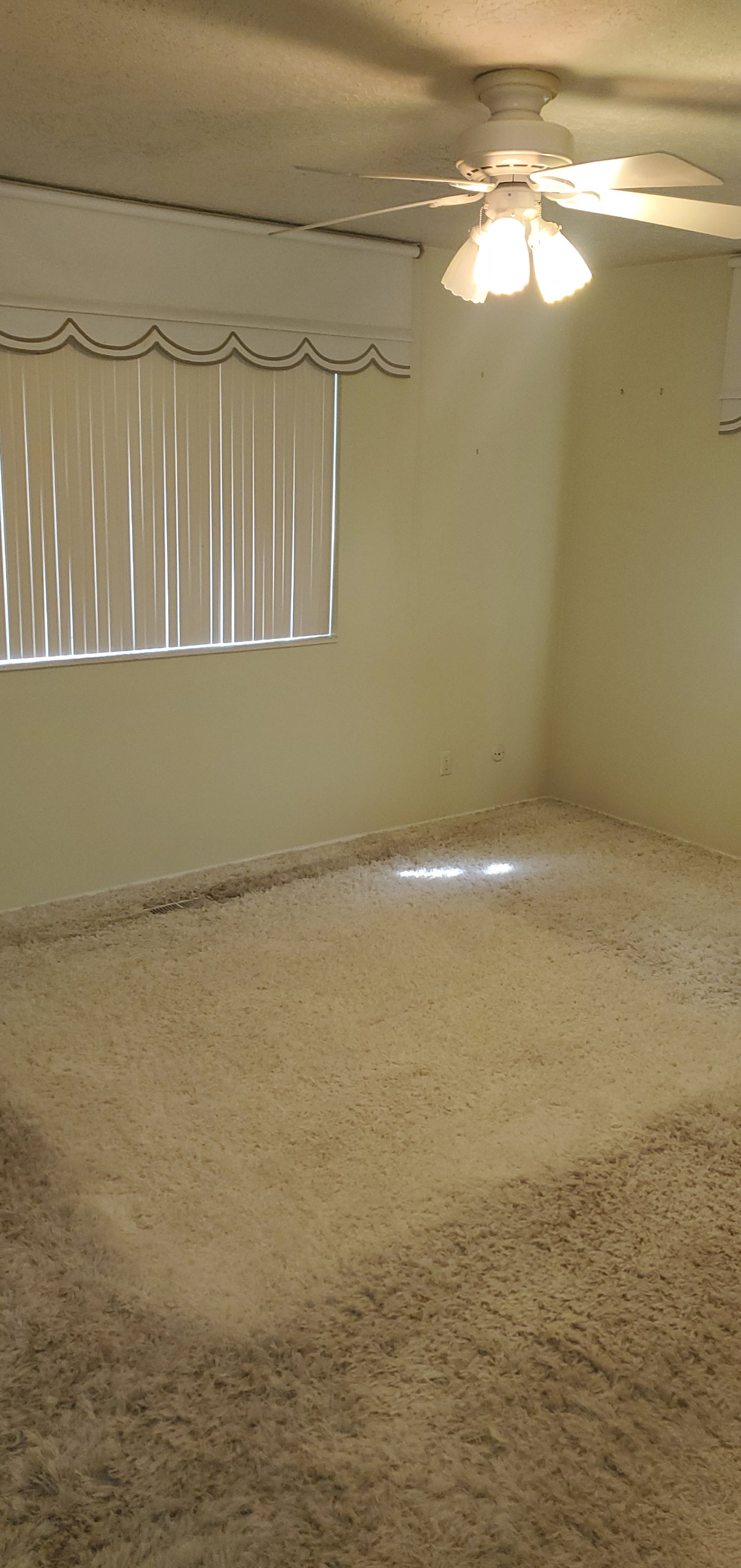 Carpeted room featuring a ceiling fan with integrated lighting
