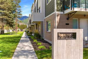 Modern townhome exterior featuring contemporary siding, brick accents, and a private balcony