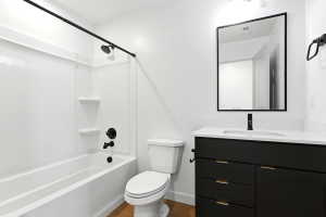 Bathroom featuring a black vanity with gold-tone hardware, white countertop, and integrated sink