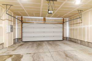 Spacious garage featuring a concrete floor, overhead lighting, and an automatic garage door opener