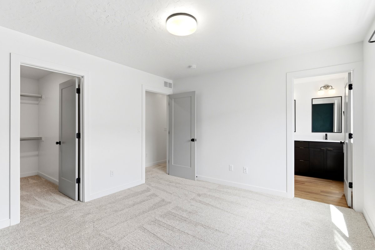 Spacious room featuring light-toned carpet flooring and white walls