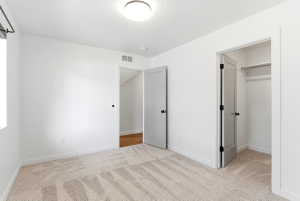 Neutral-toned wall-to-wall carpeting complements bright white walls and trim