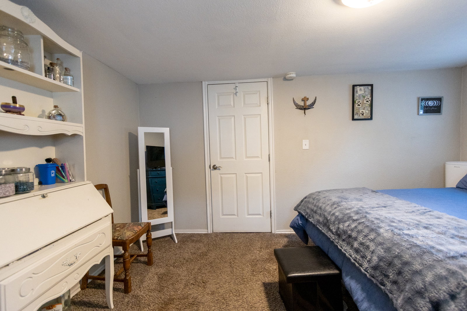 Carpeted room featuring a ceiling-mounted light fixture, white interior door, and light-toned walls