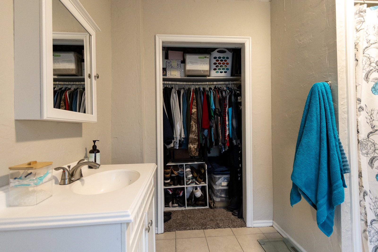 Bathroom vanity with white cabinetry, an integrated sink, and a brushed nickel faucet