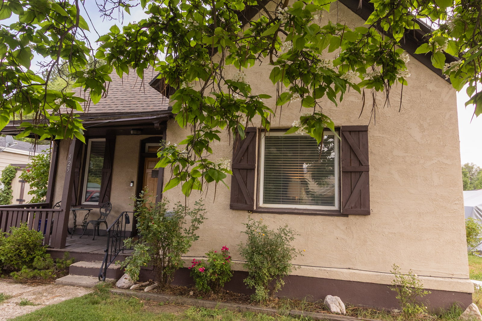Stucco exterior with dark trim and decorative shutters