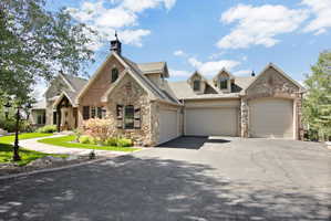 Stone and brick exterior with a prominent asphalt driveway