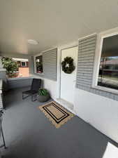 Covered porch featuring a painted concrete floor