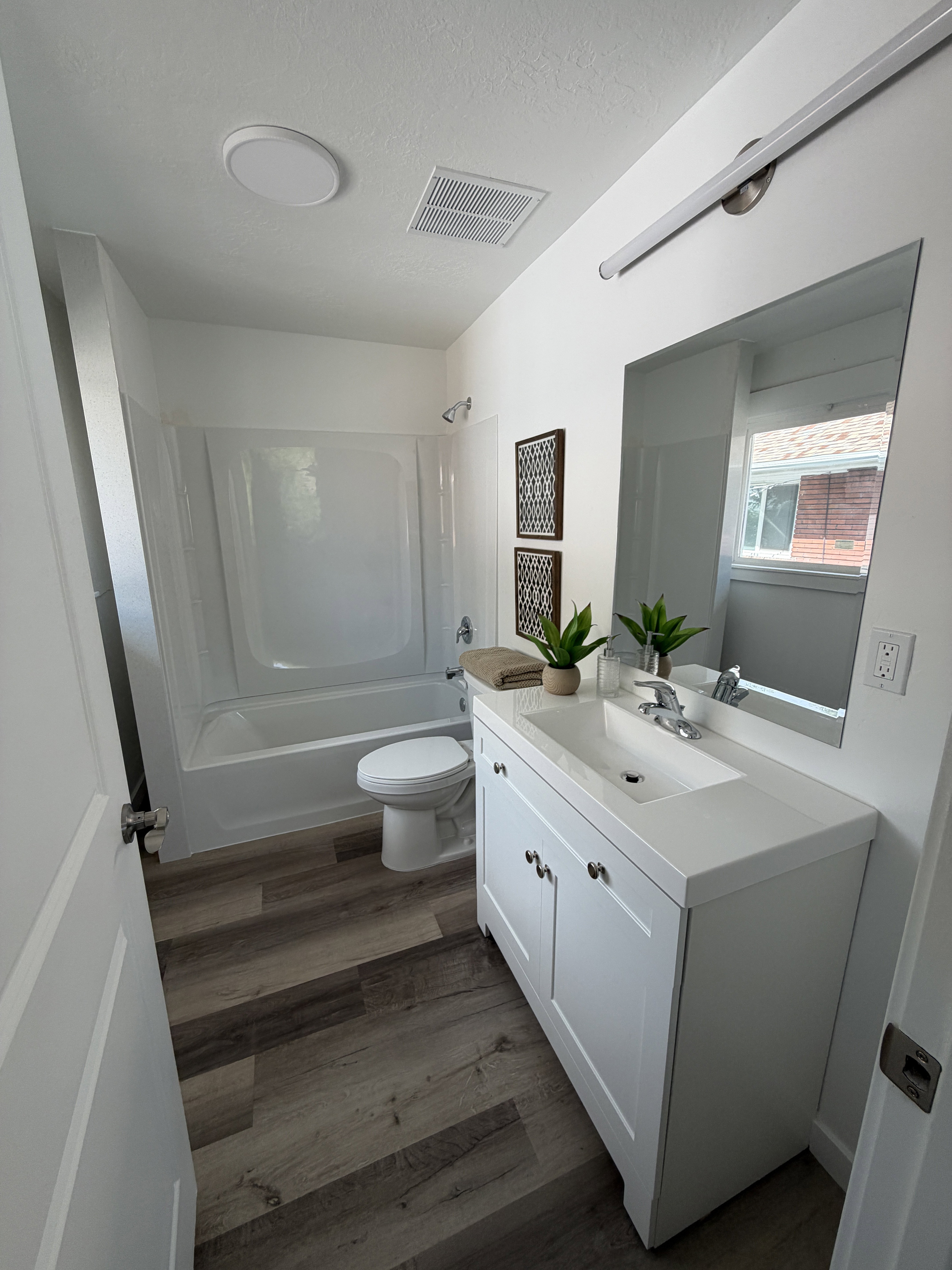 White vanity with shaker-style cabinetry, an integrated sink, and brushed nickel hardware
