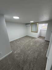 Carpeted room featuring recessed lighting, a wall-mounted mini-split unit, and a window with a deep sill