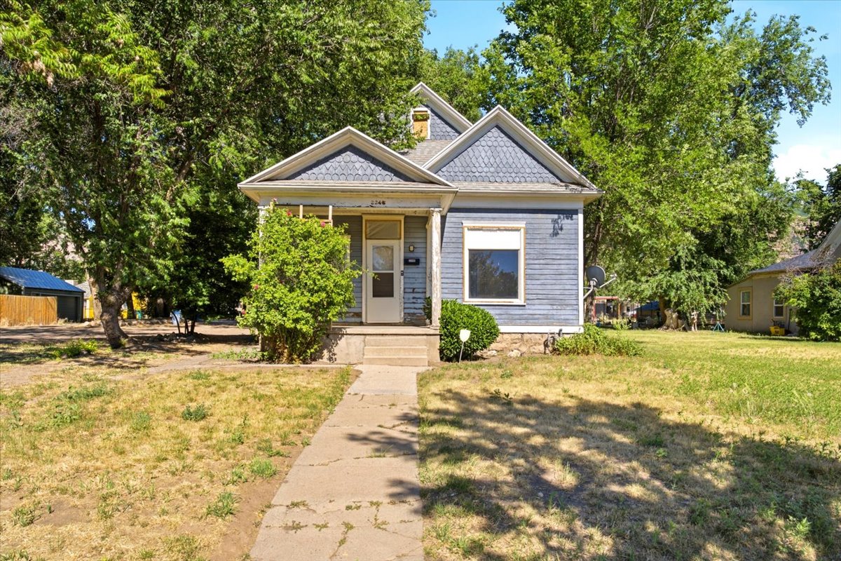 Charming single-story residence featuring blue siding, white trim, and a prominent front gable with decorative shingles