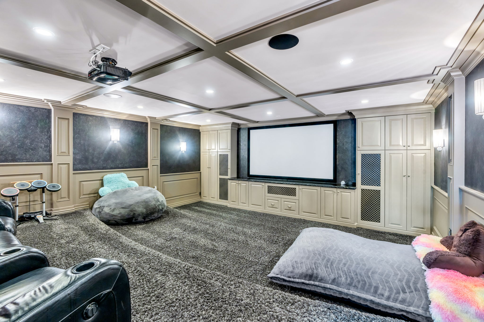 Dedicated media room featuring a large projection screen and ceiling-mounted projector