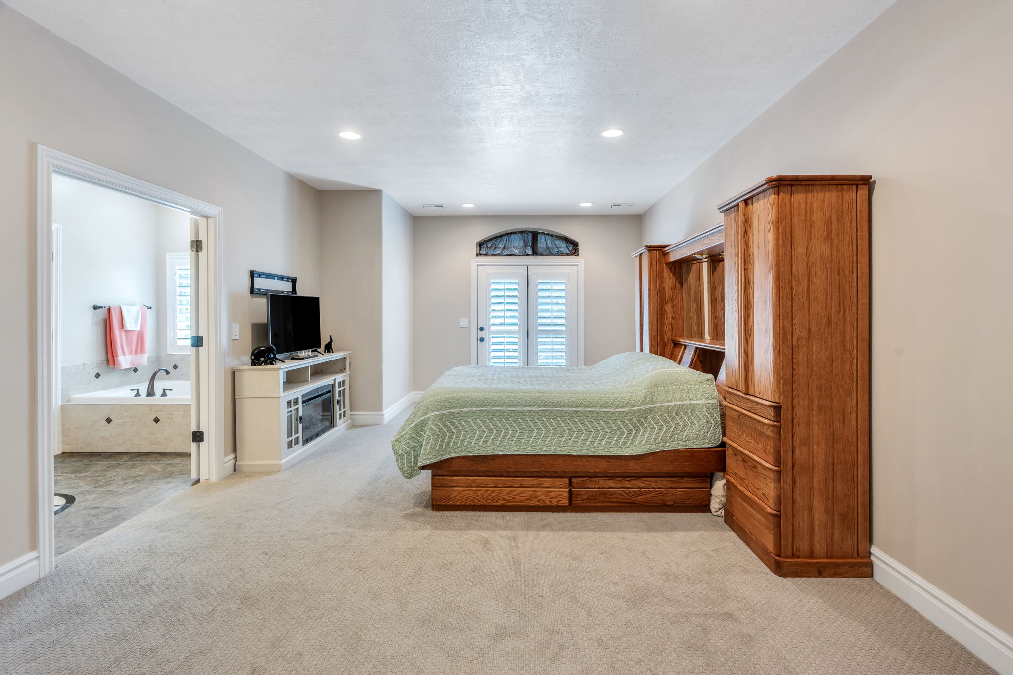Carpeted sleeping area with a built-in wood bed frame featuring storage drawers