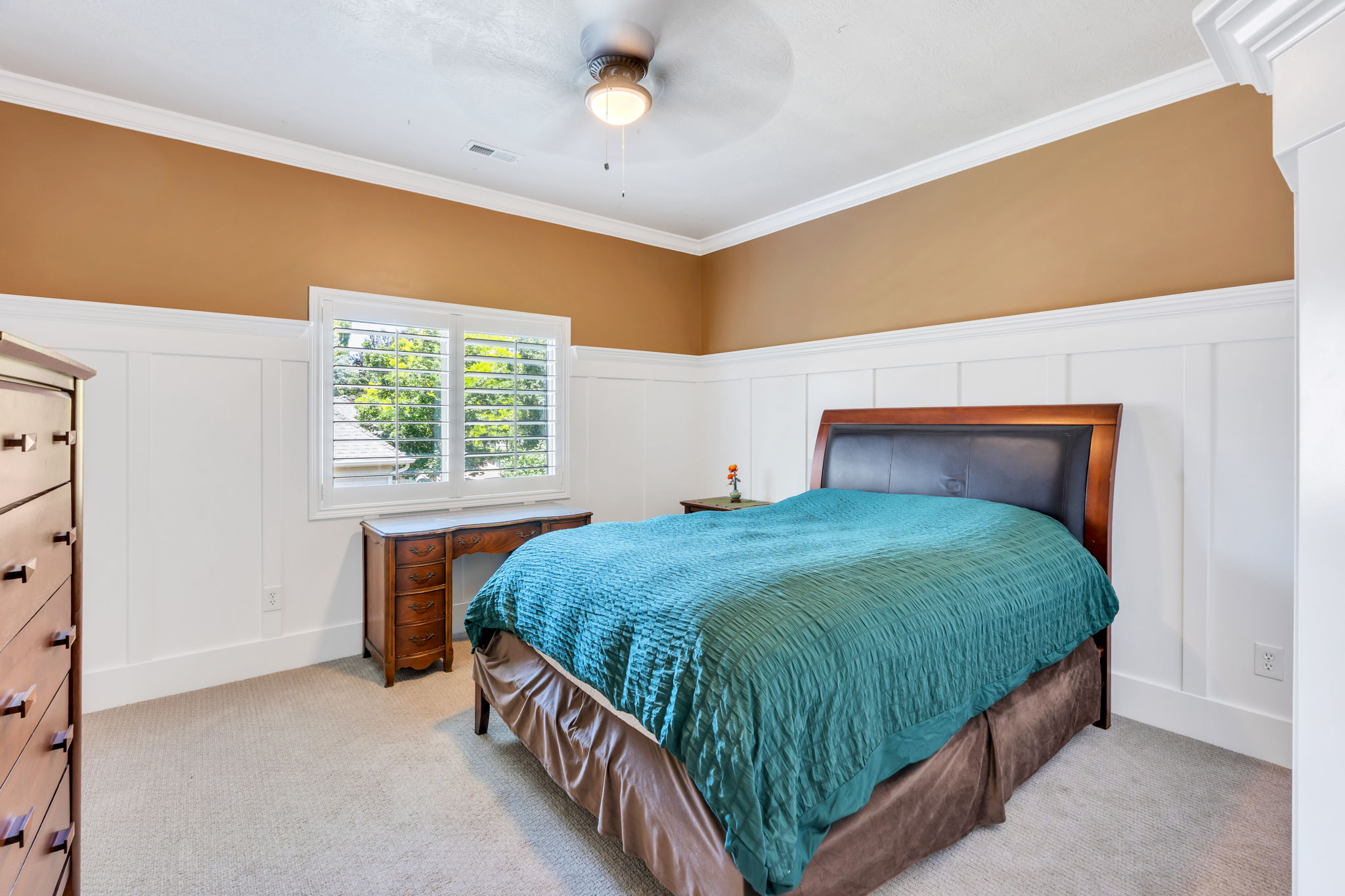 Neutral-toned carpeting extends throughout this room, featuring a white board and batten wall treatment complementing the crown molding
