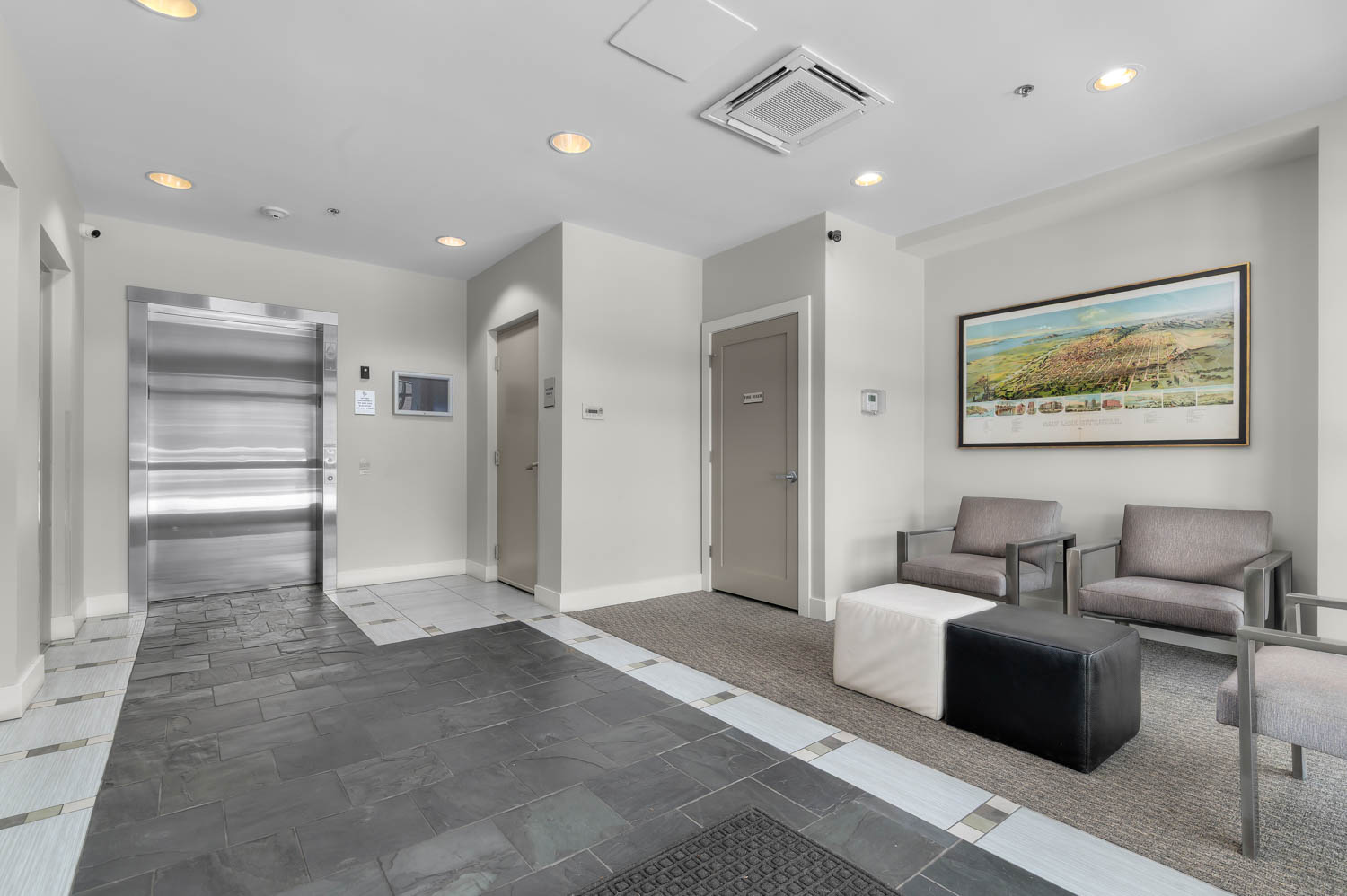 Lobby area featuring mixed material flooring with dark slate-style tiles and patterned light tiles