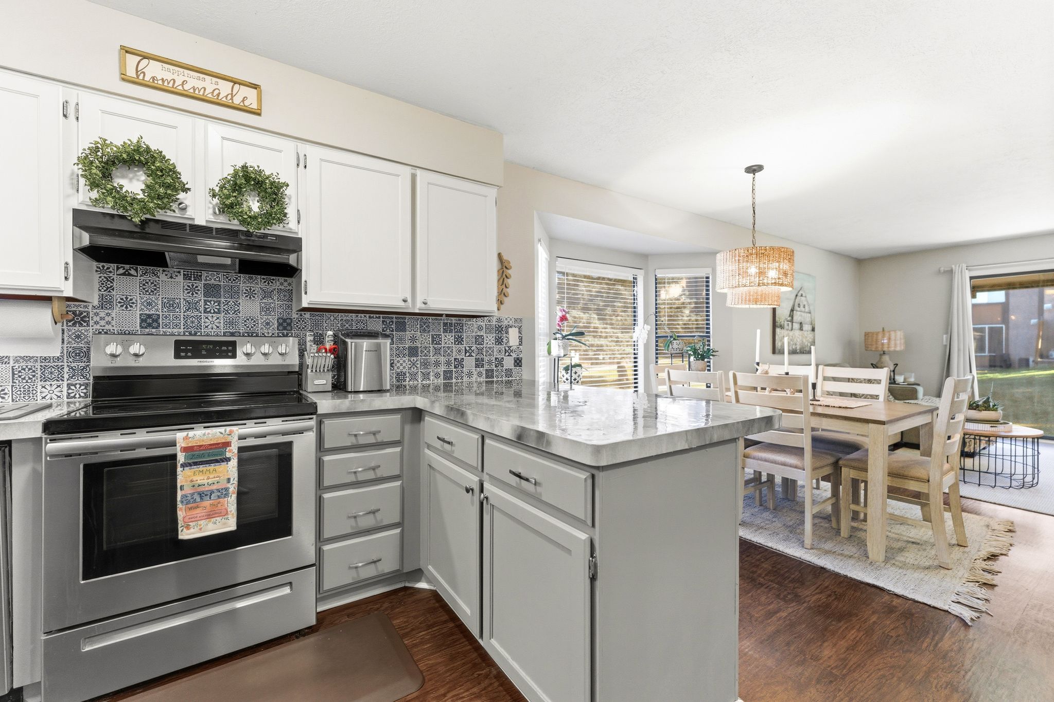 Kitchen featuring white upper cabinetry, gray lower cabinetry, and a patterned tile backsplash