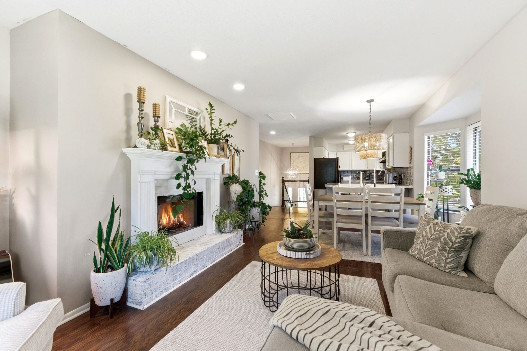 Living area featuring a white mantel fireplace with a painted brick hearth