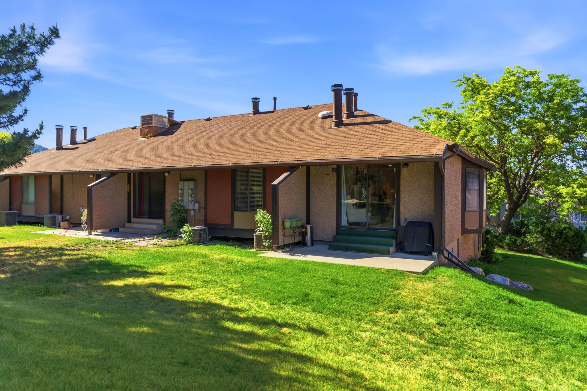 Multi-unit exterior with a brown shingle roof and neutral-toned siding